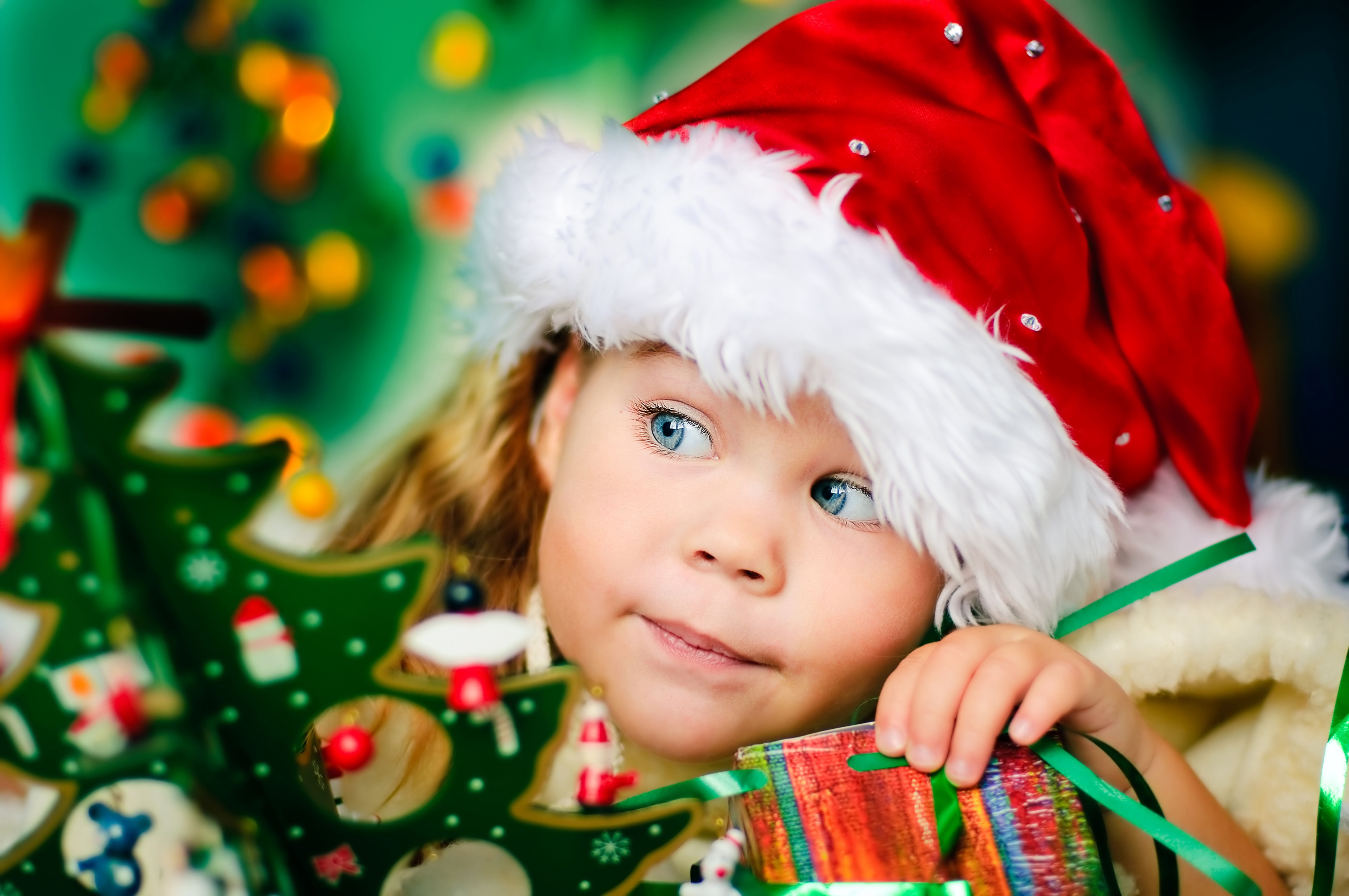 Girl in Santa hat with Christmas tree and gift HD Wallpaper