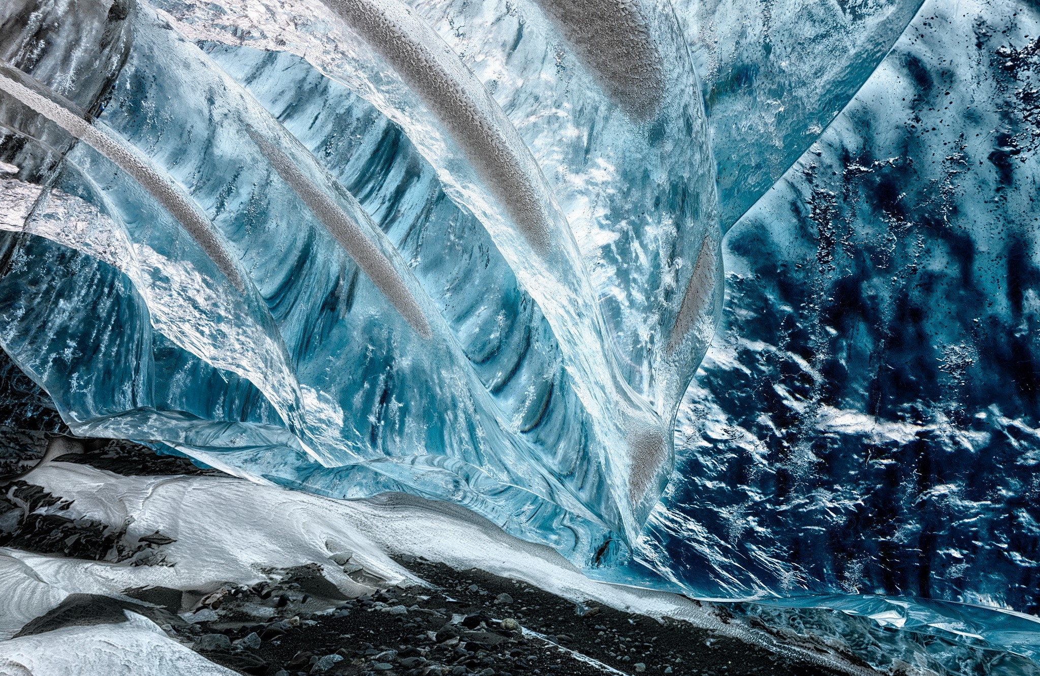 Inside a blue ice cave with textured walls HD Wallpaper