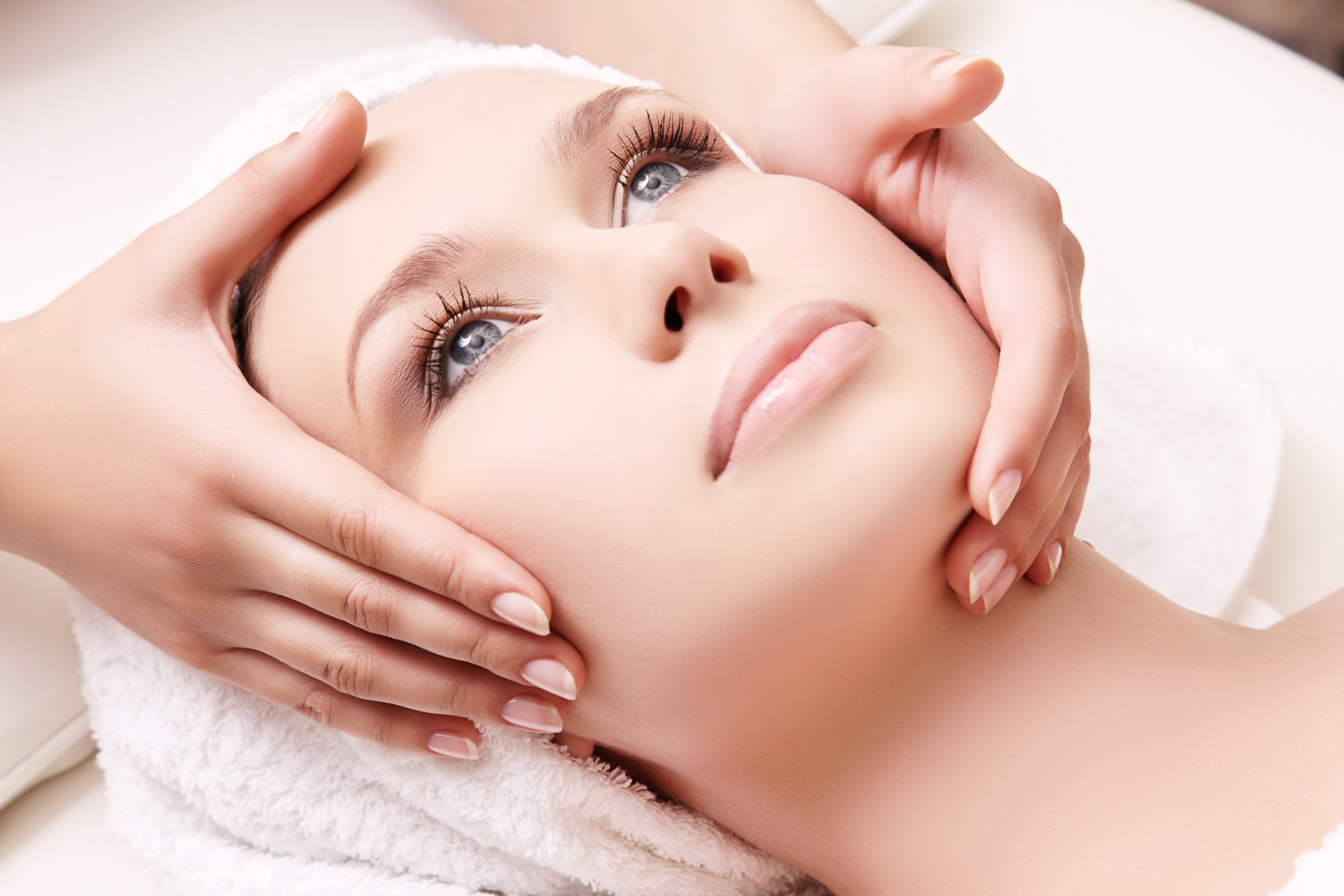 Woman receiving a facial massage with a towel HD Wallpaper