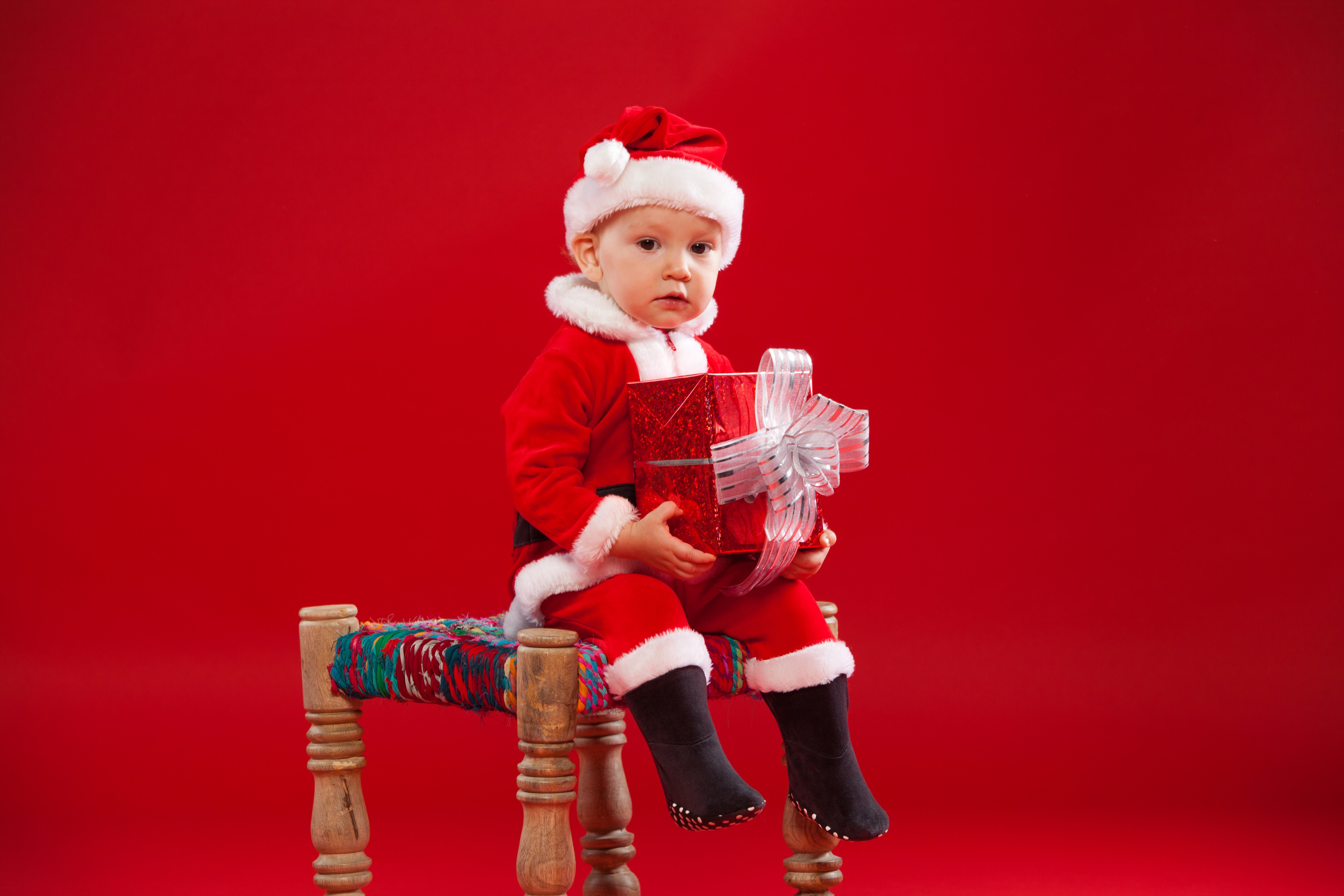 Baby in Santa costume holding a gift HD Wallpaper