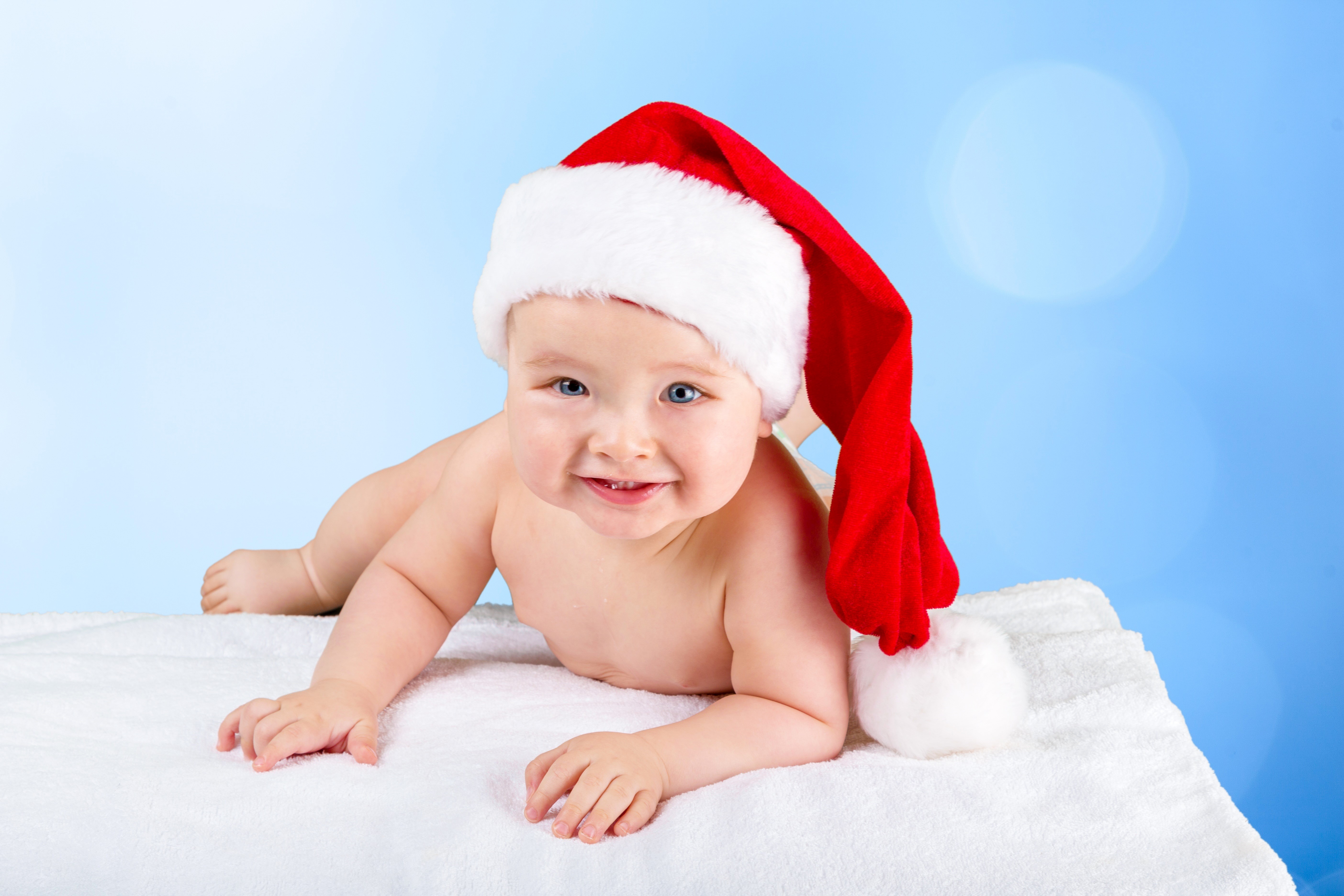 Baby in Santa hat on white blanket HD Wallpaper