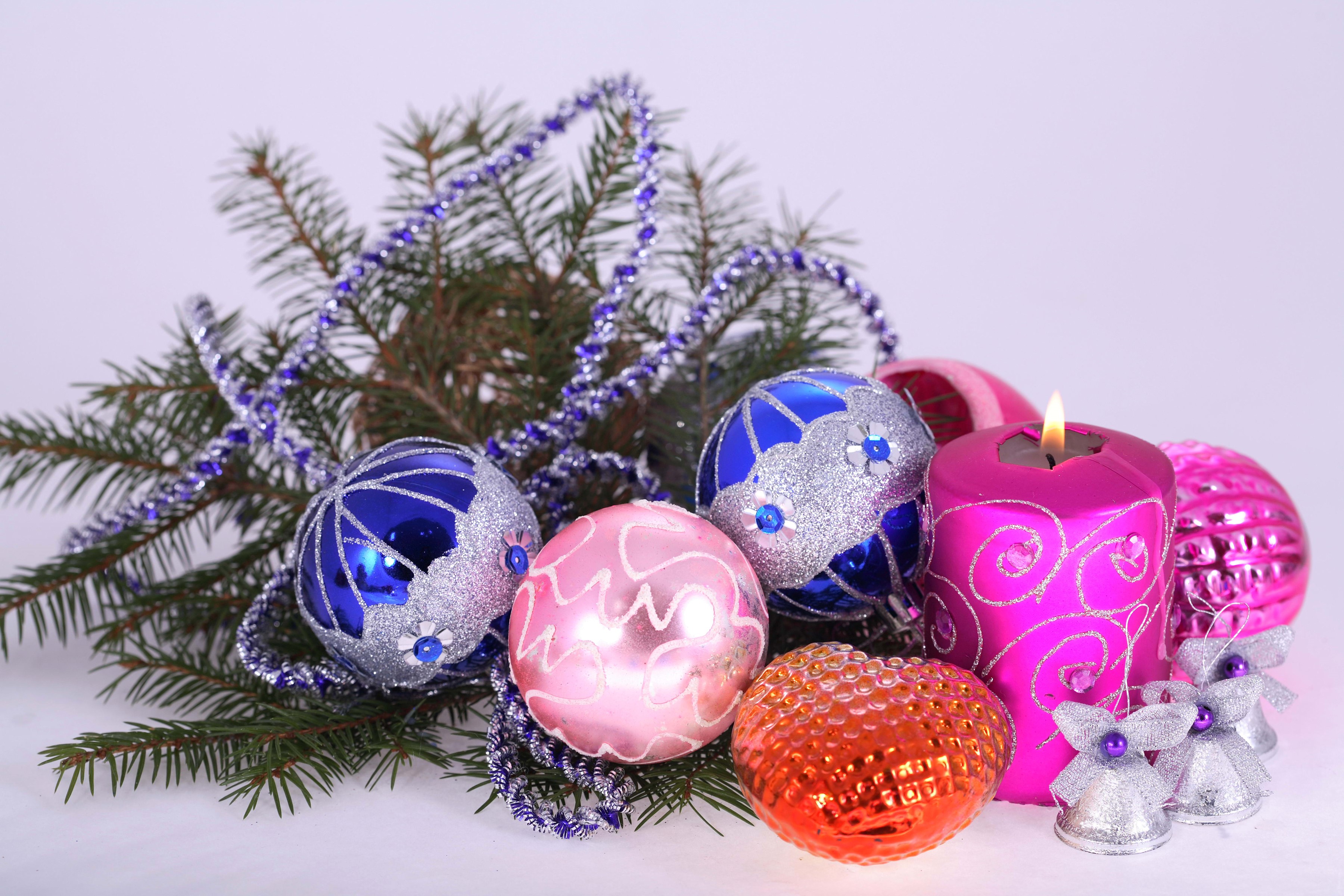 Christmas ornaments and lit candle on pine branches HD Wallpaper