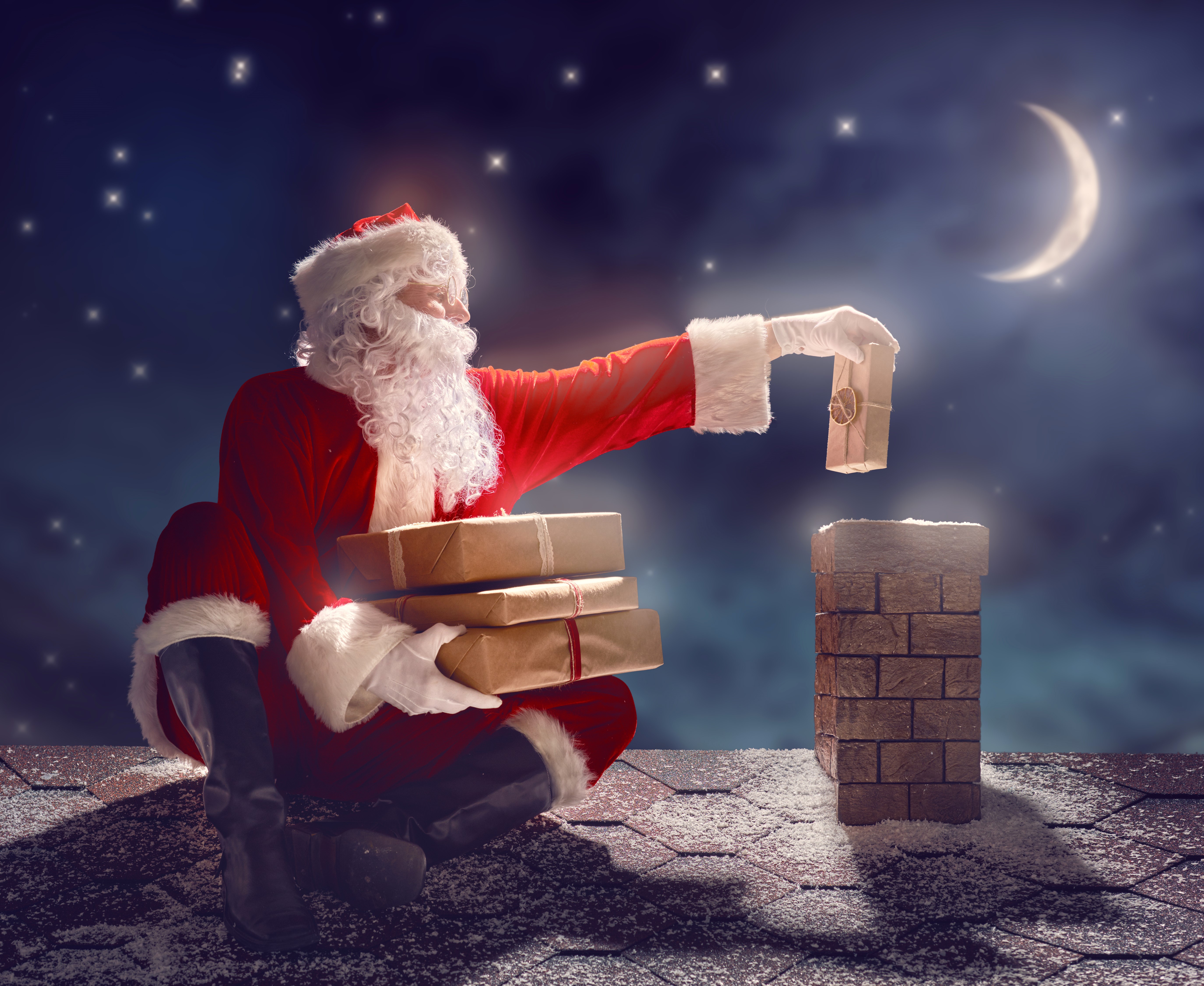 Santa Claus on a roof with gifts at night HD Wallpaper