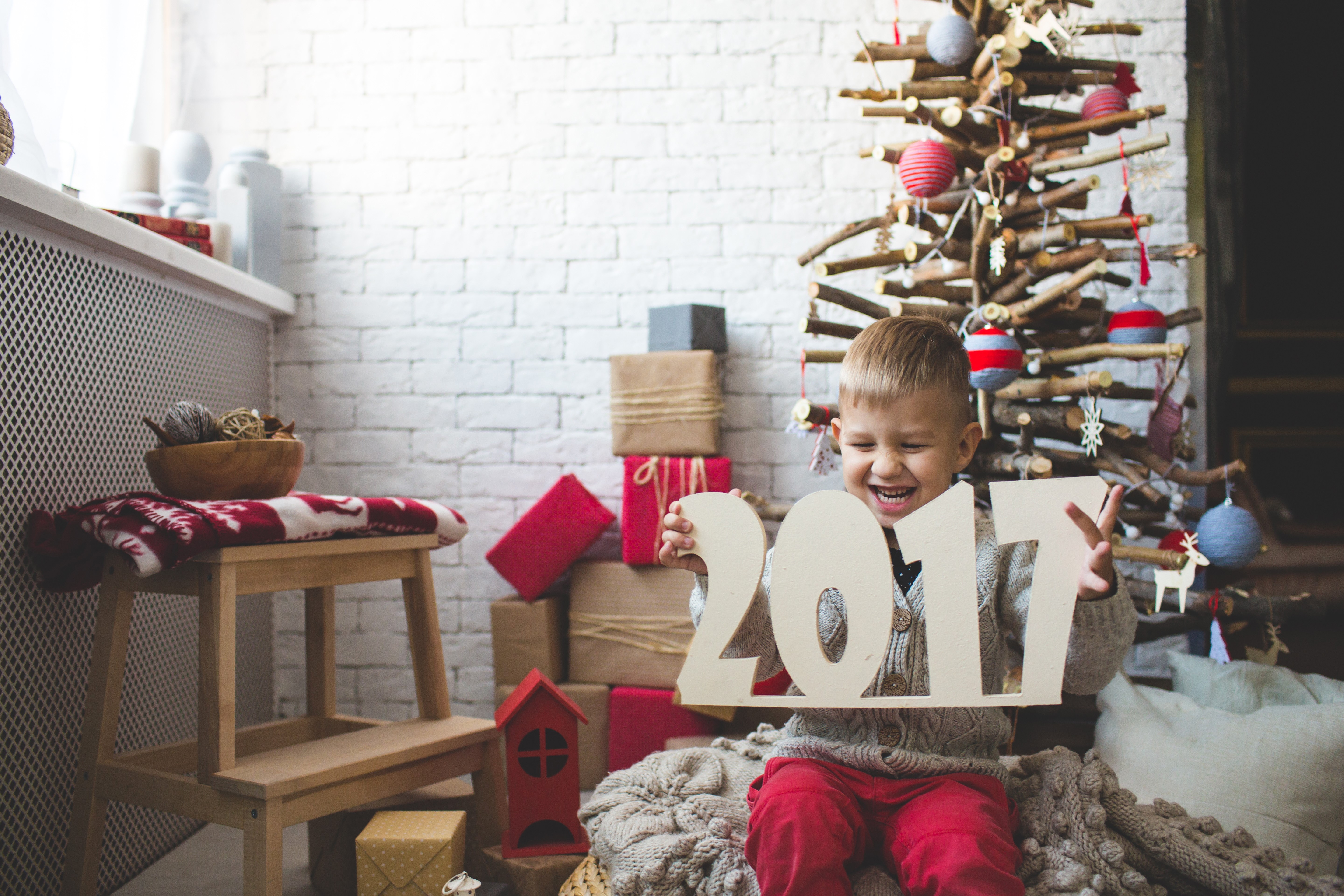 Boy holding "2017" near Christmas tree HD Wallpaper