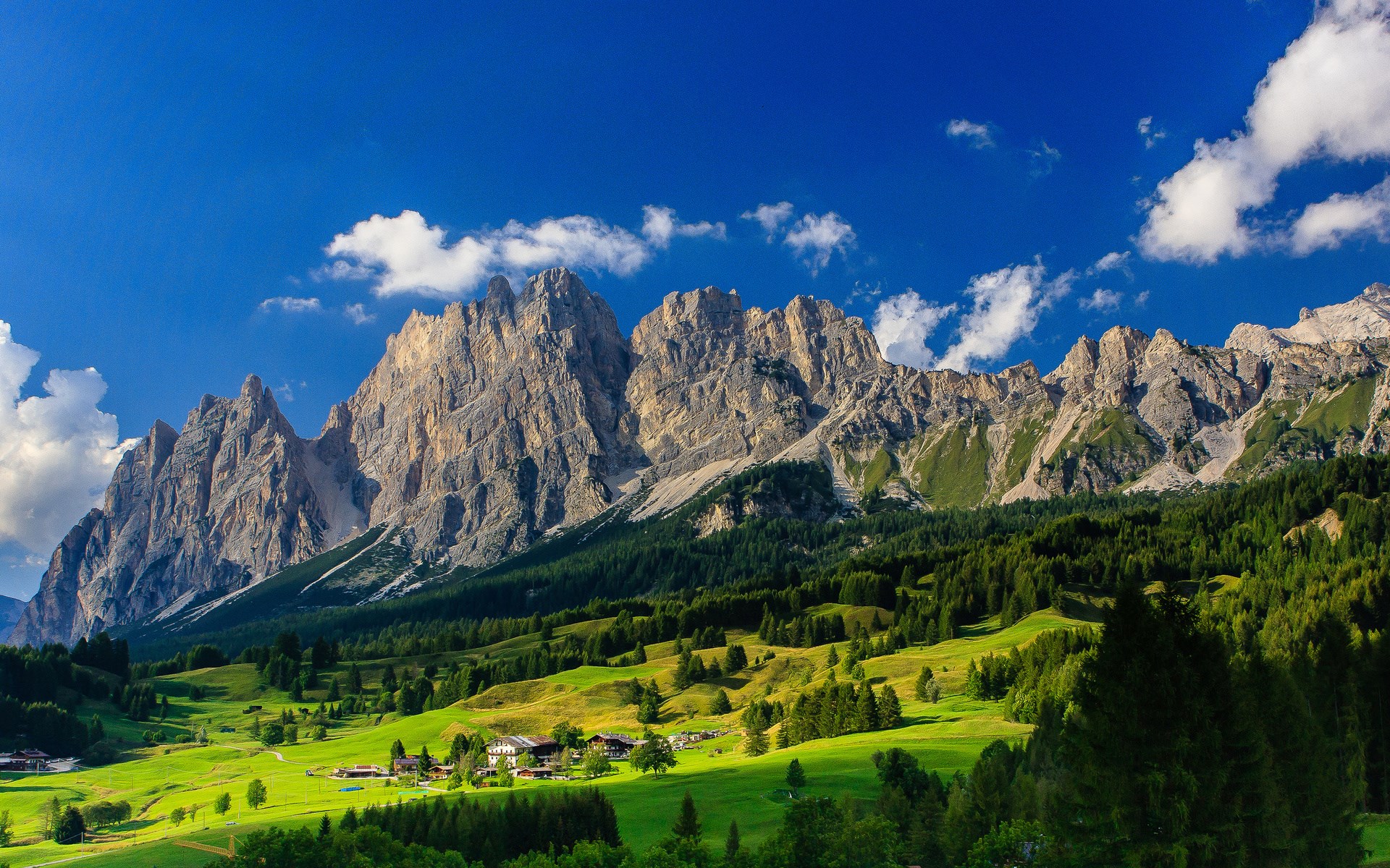 Mountain range with green valley and village HD Wallpaper