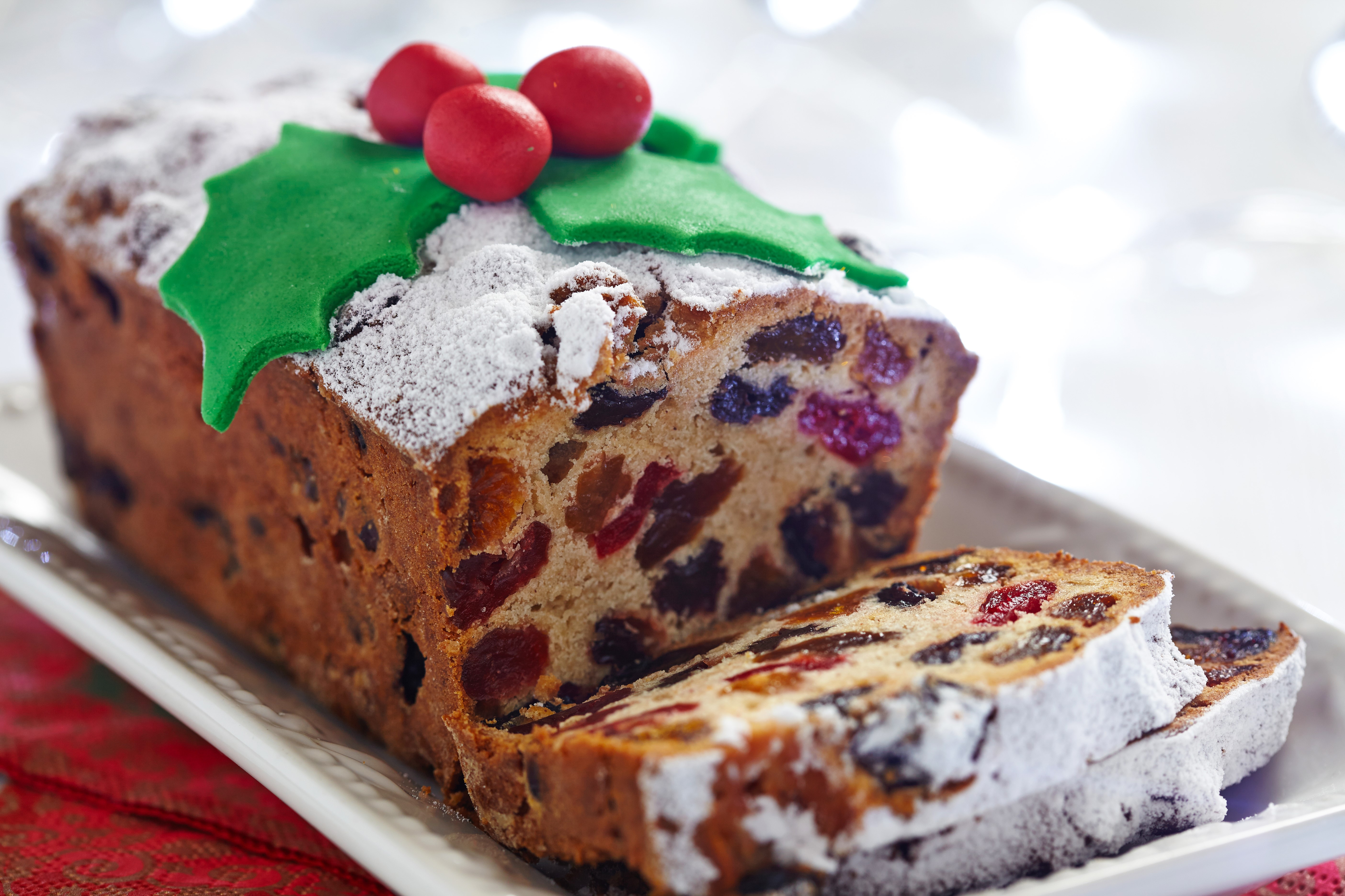Christmas fruitcake with powdered sugar and holly decoration HD Wallpaper