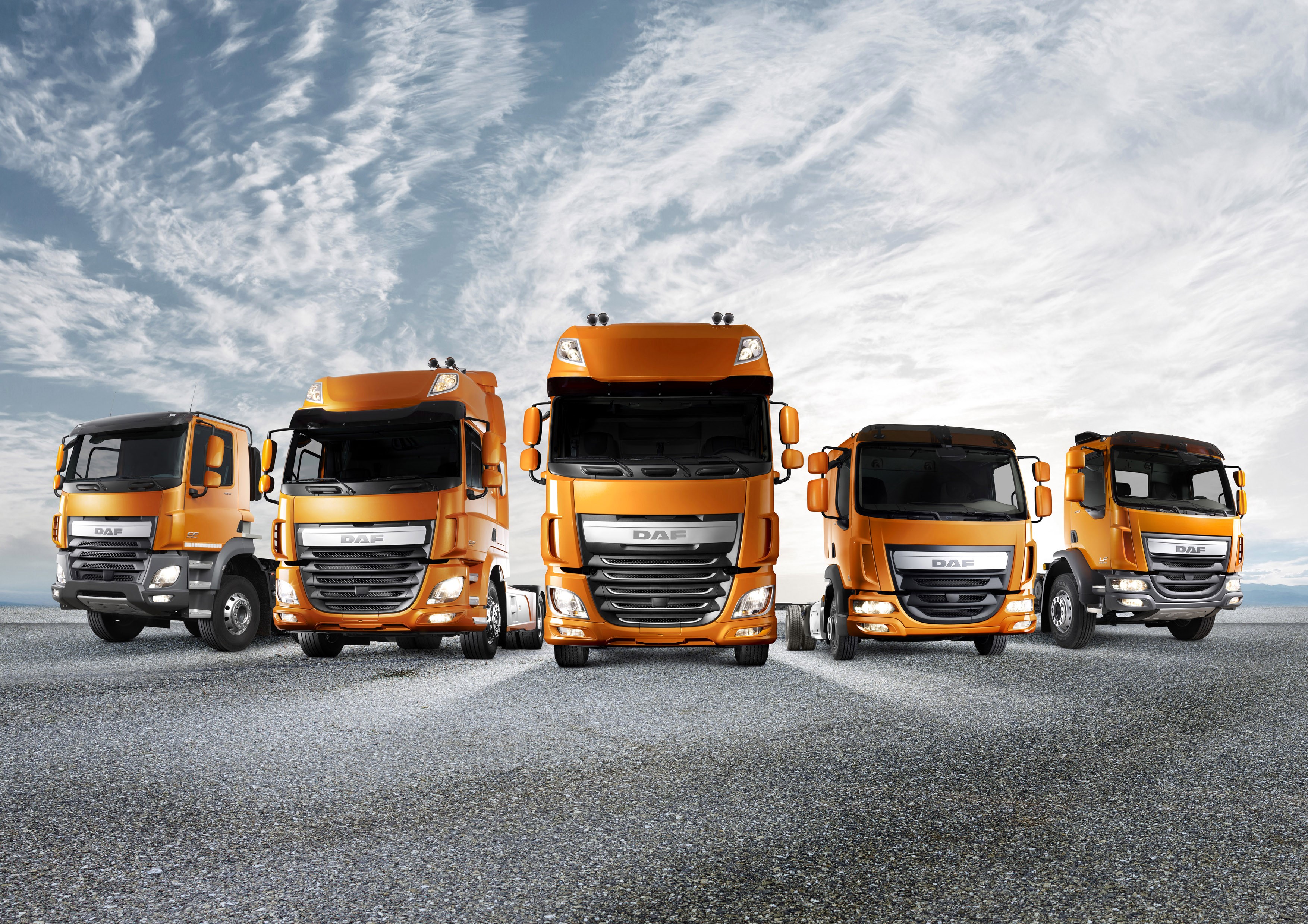Five orange DAF trucks lined up HD Wallpaper