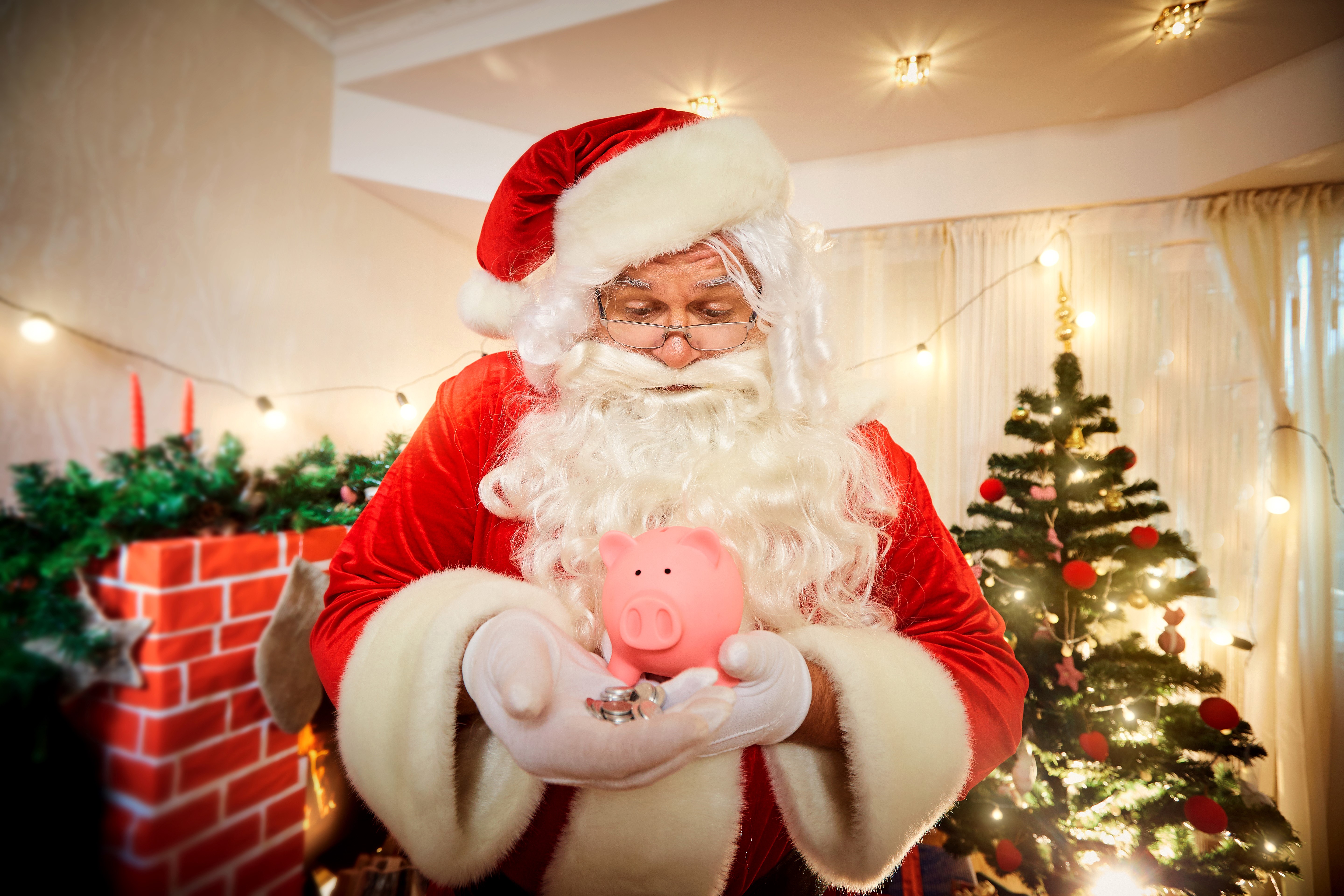 Santa Claus holding a piggy bank and coins HD Wallpaper
