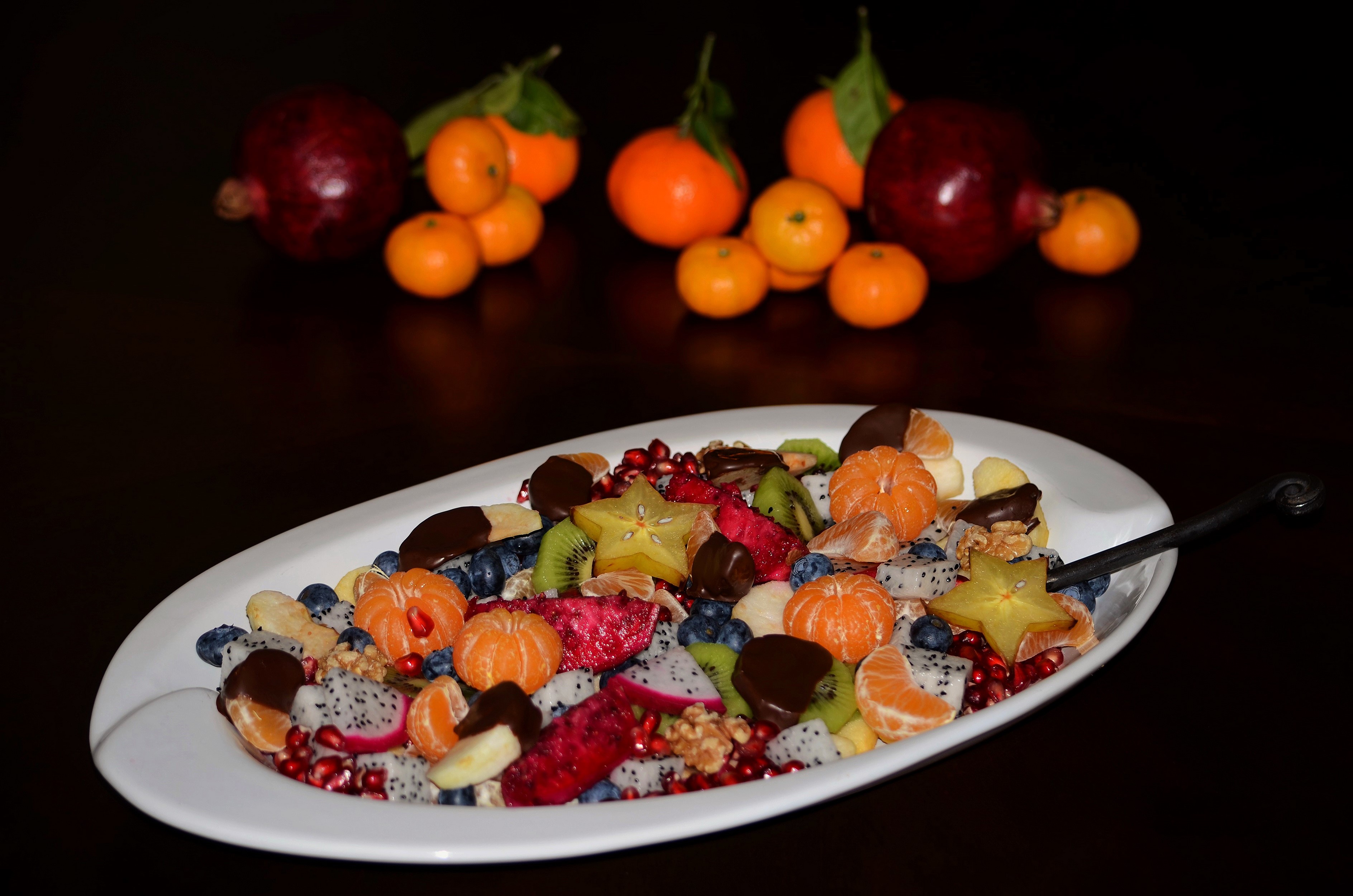 Fruit salad with pomegranates and mandarins on a plate HD Wallpaper
