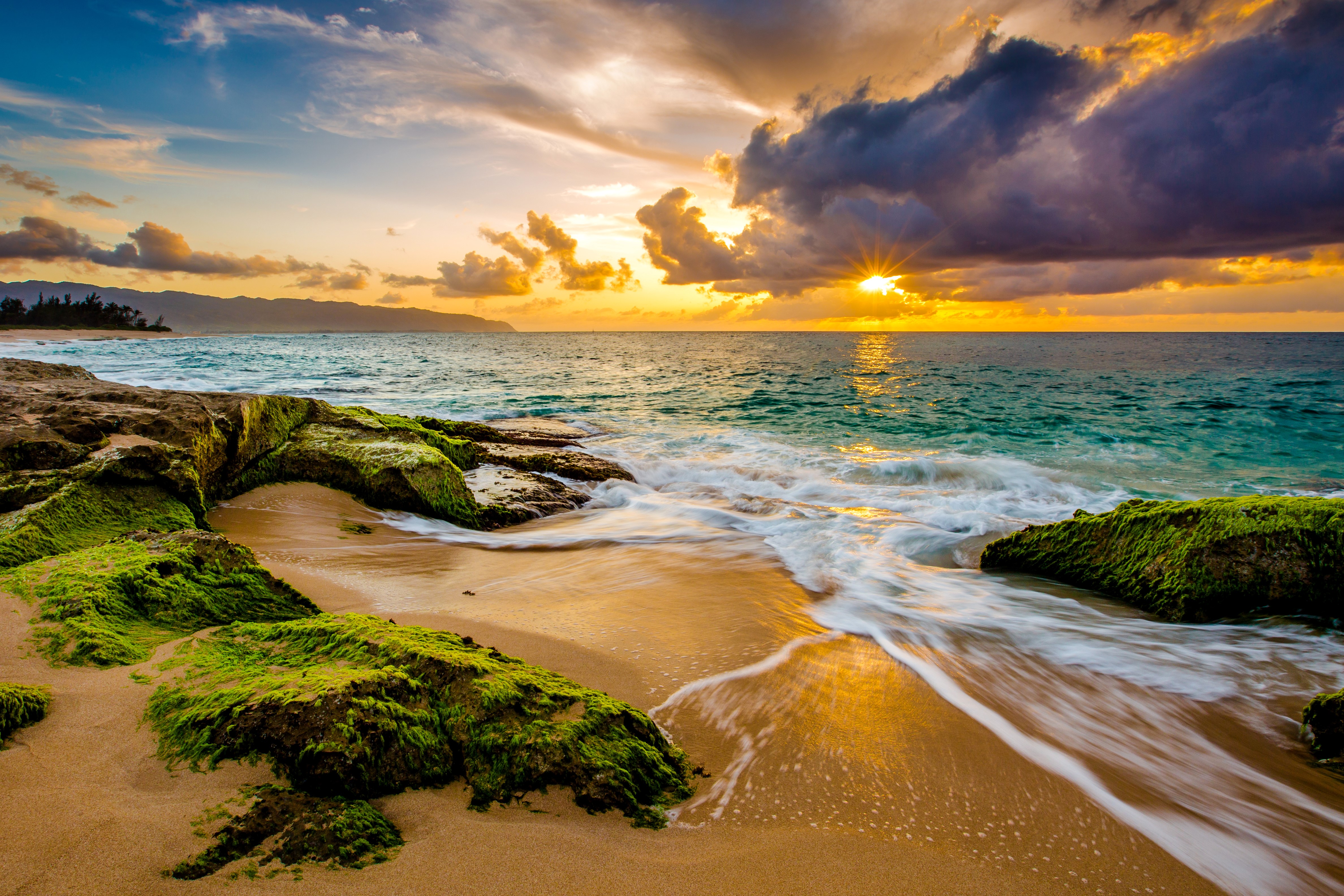 Sunset over the ocean with mossy rocks on the beach in Hawaii HD Wallpaper