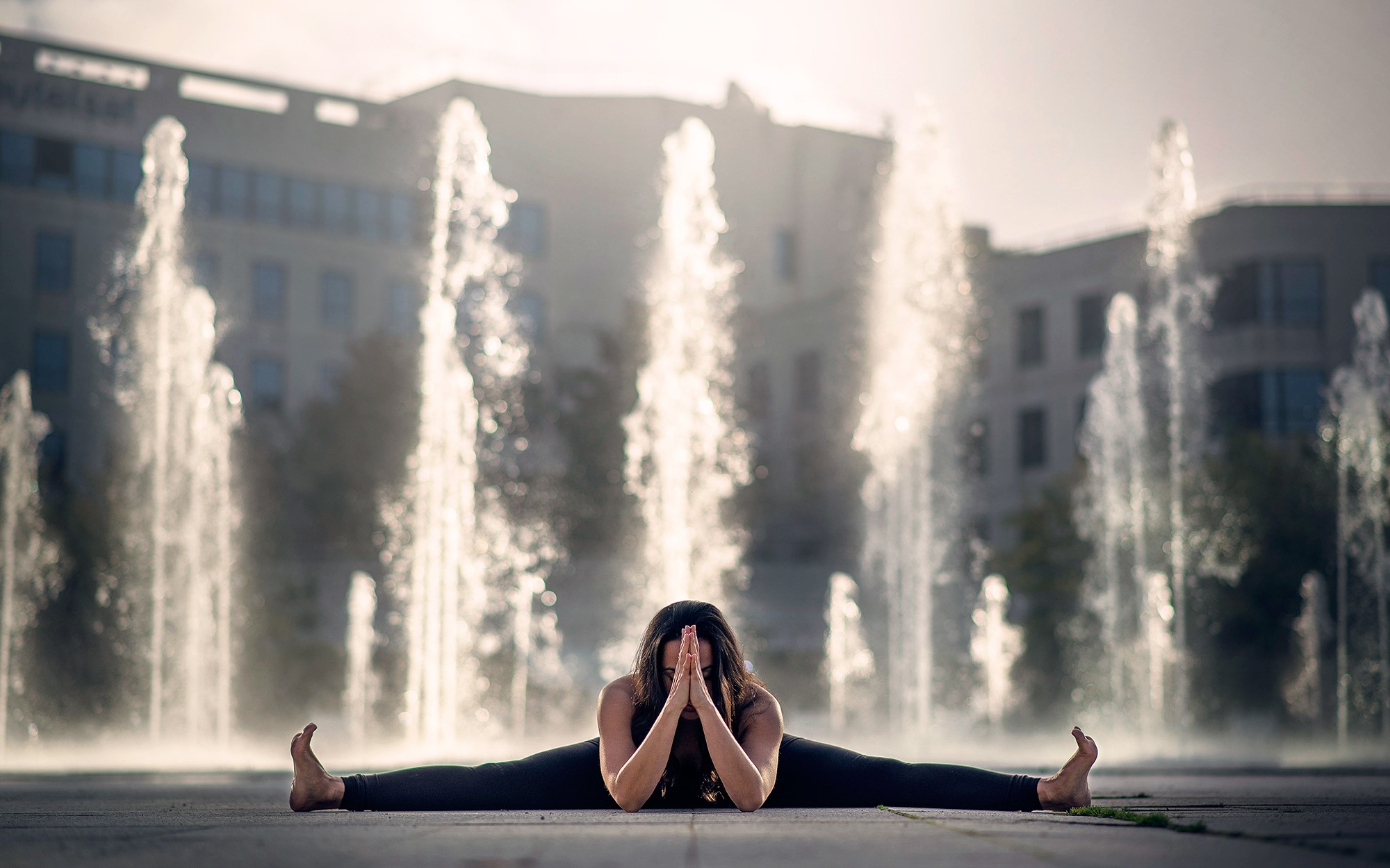 Woman doing splits in front of fountains HD Wallpaper