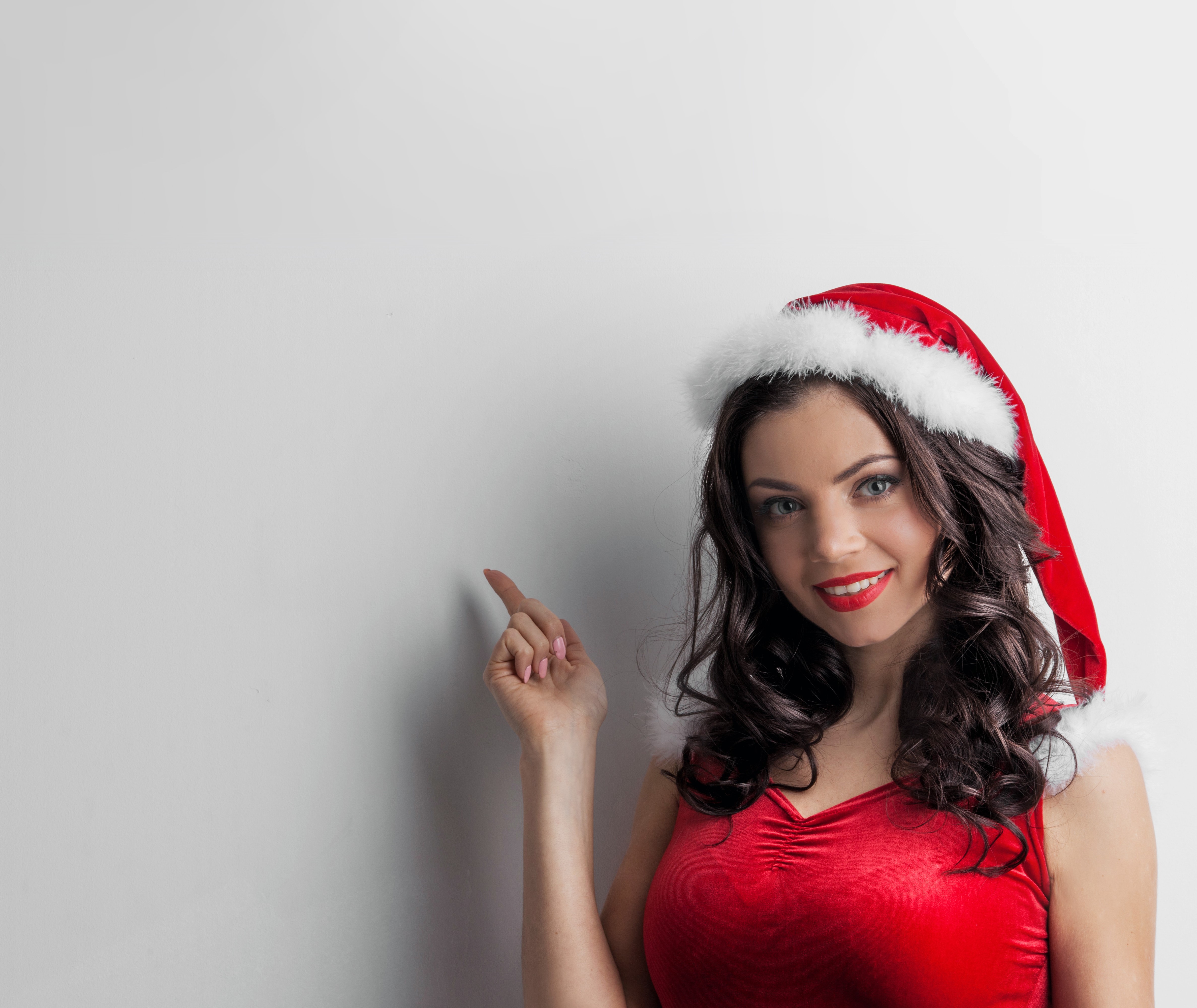 Woman in Santa hat pointing HD Wallpaper