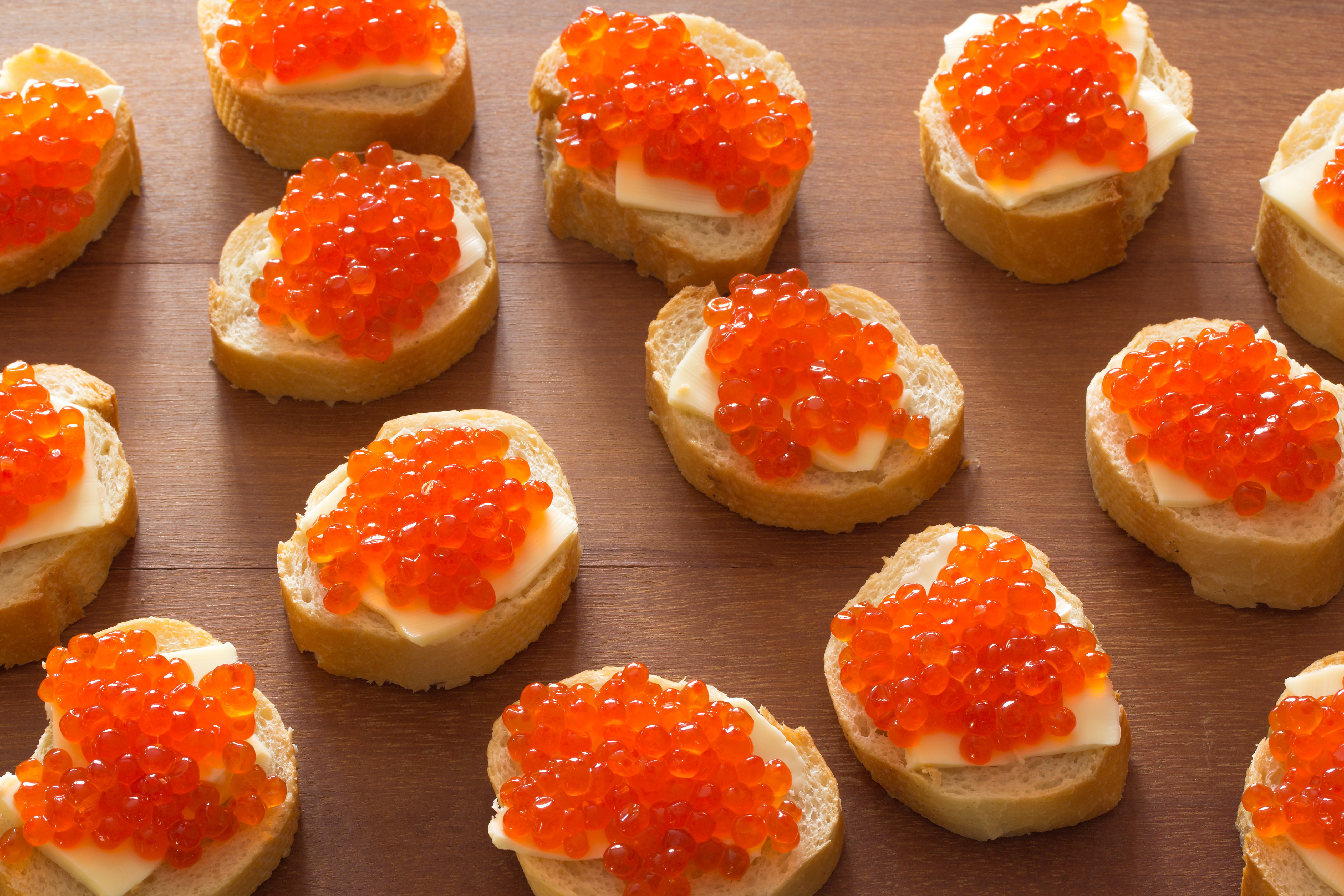 Bread slices with butter and red caviar on wooden planks HD Wallpaper