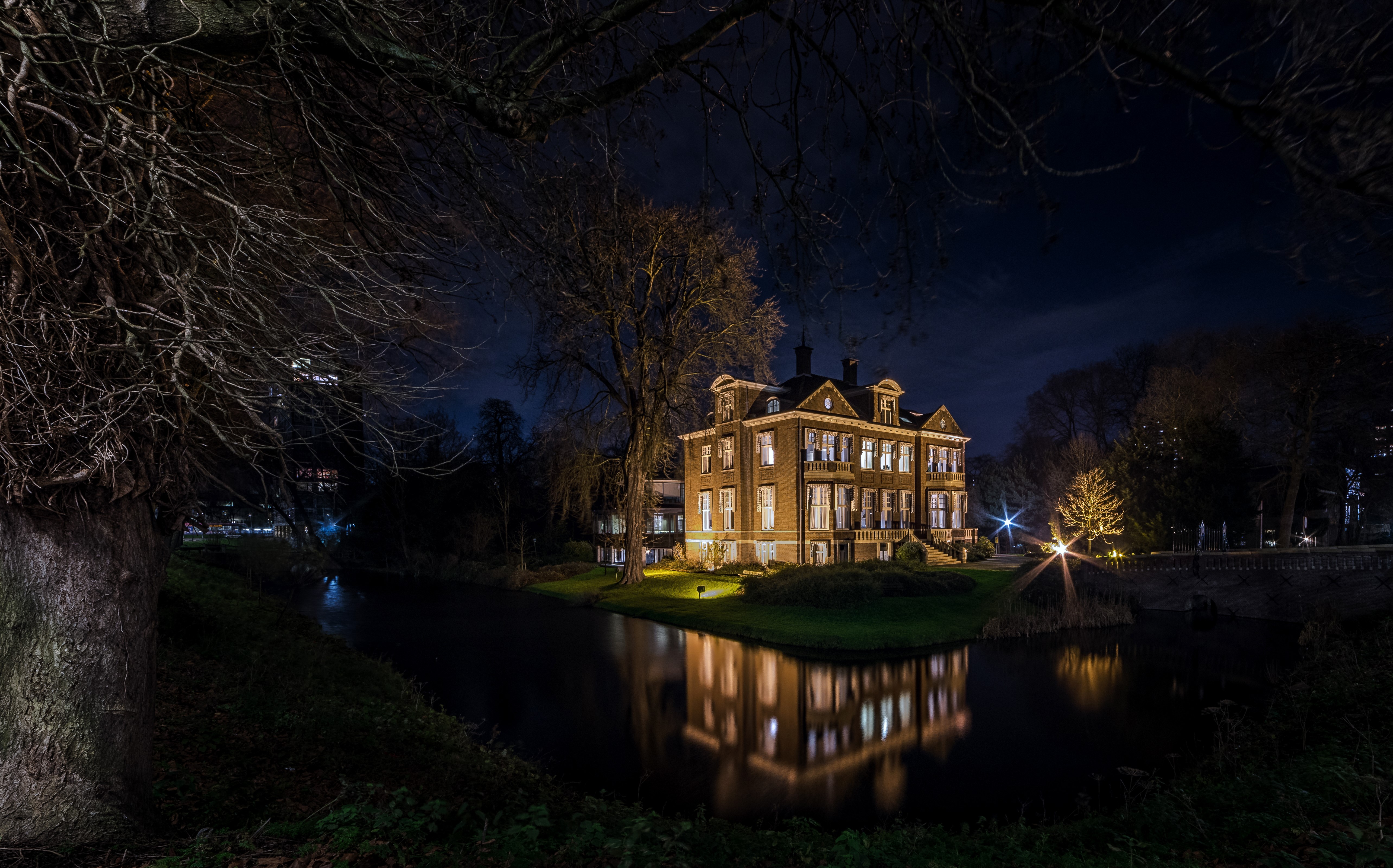 Illuminated Mansion by River at Night in Netherlands HD Wallpaper