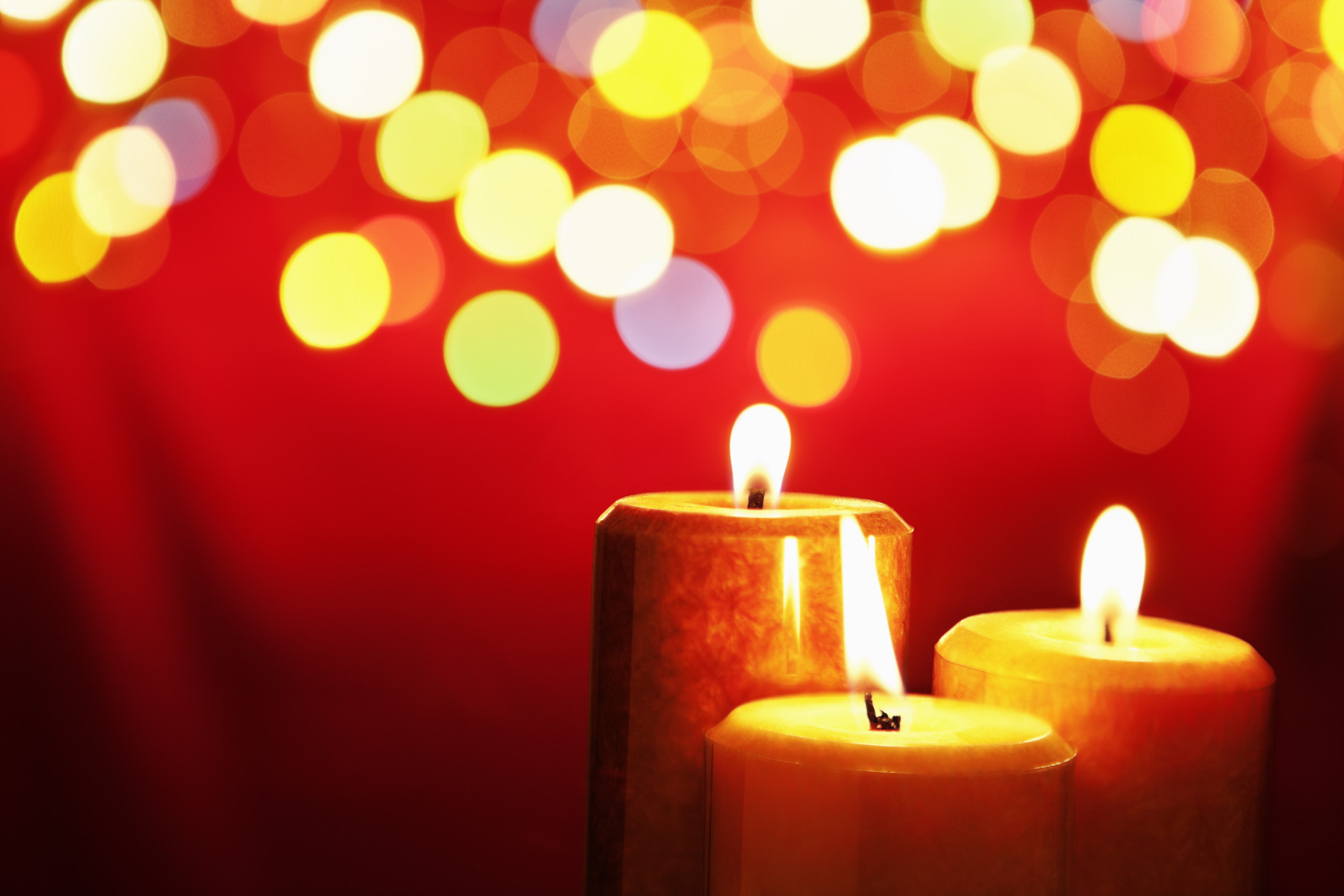 Three lit candles with bokeh lights HD Wallpaper