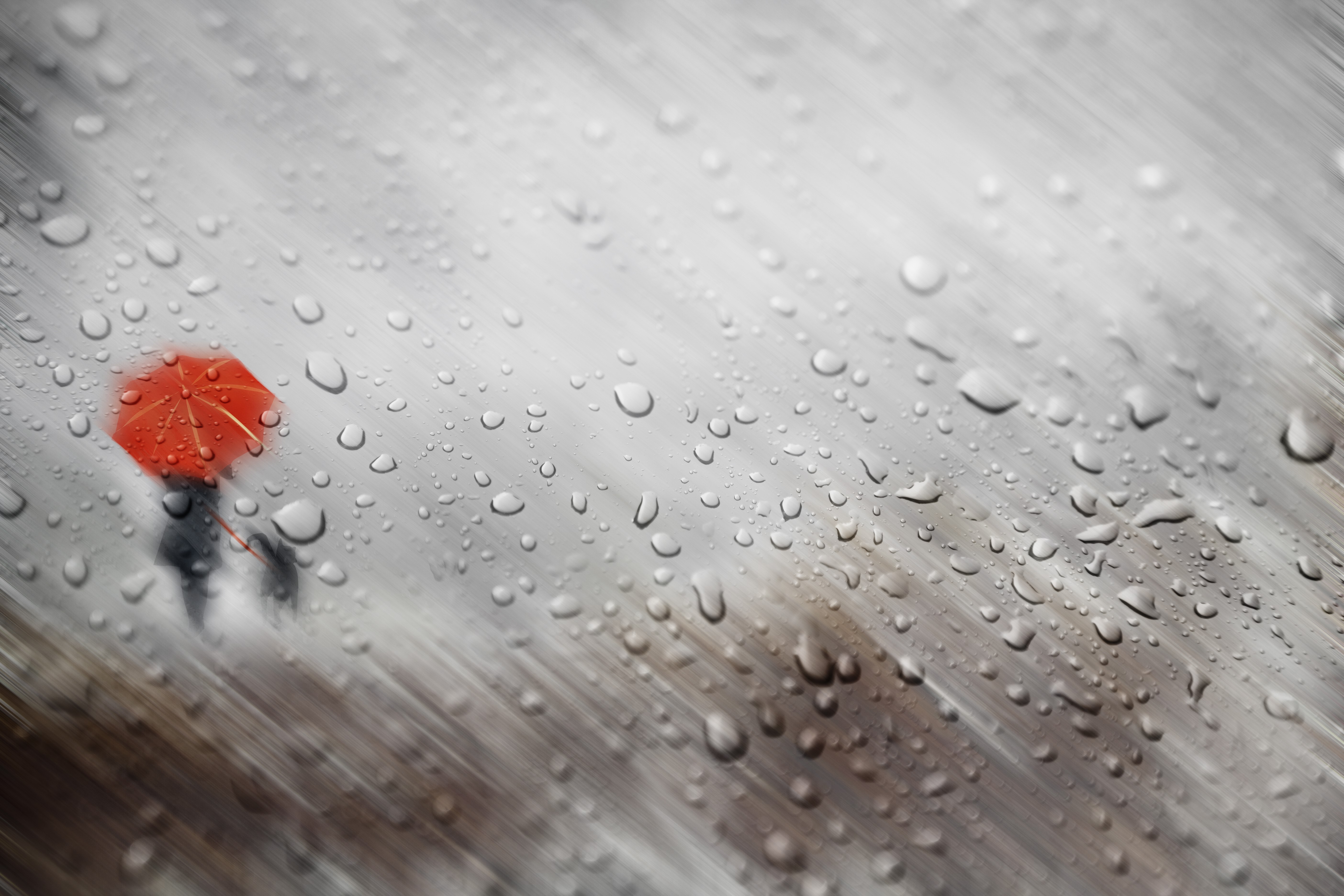 Raindrops on glass with a person holding an umbrella HD Wallpaper