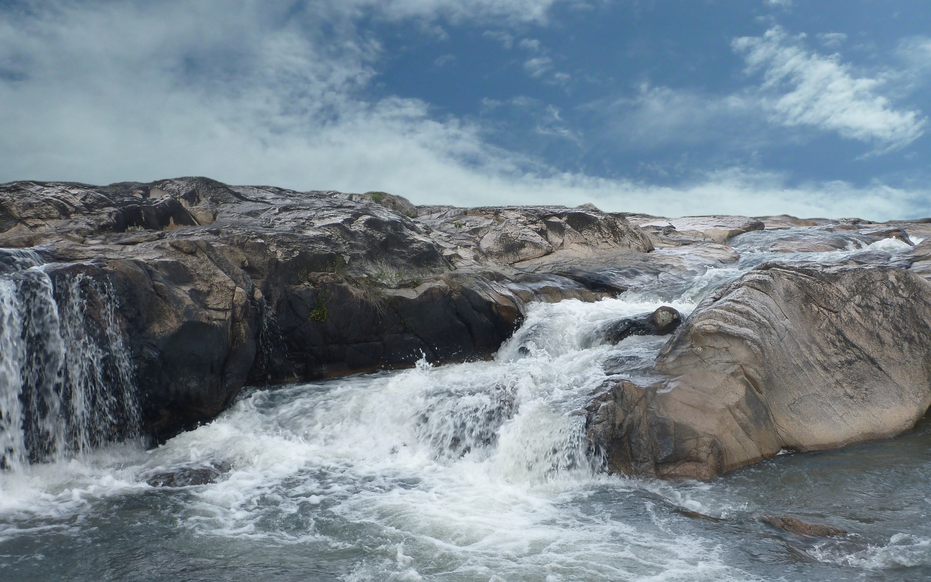 Rocky waterfall with turbulent water and cloudy sky HD Wallpaper