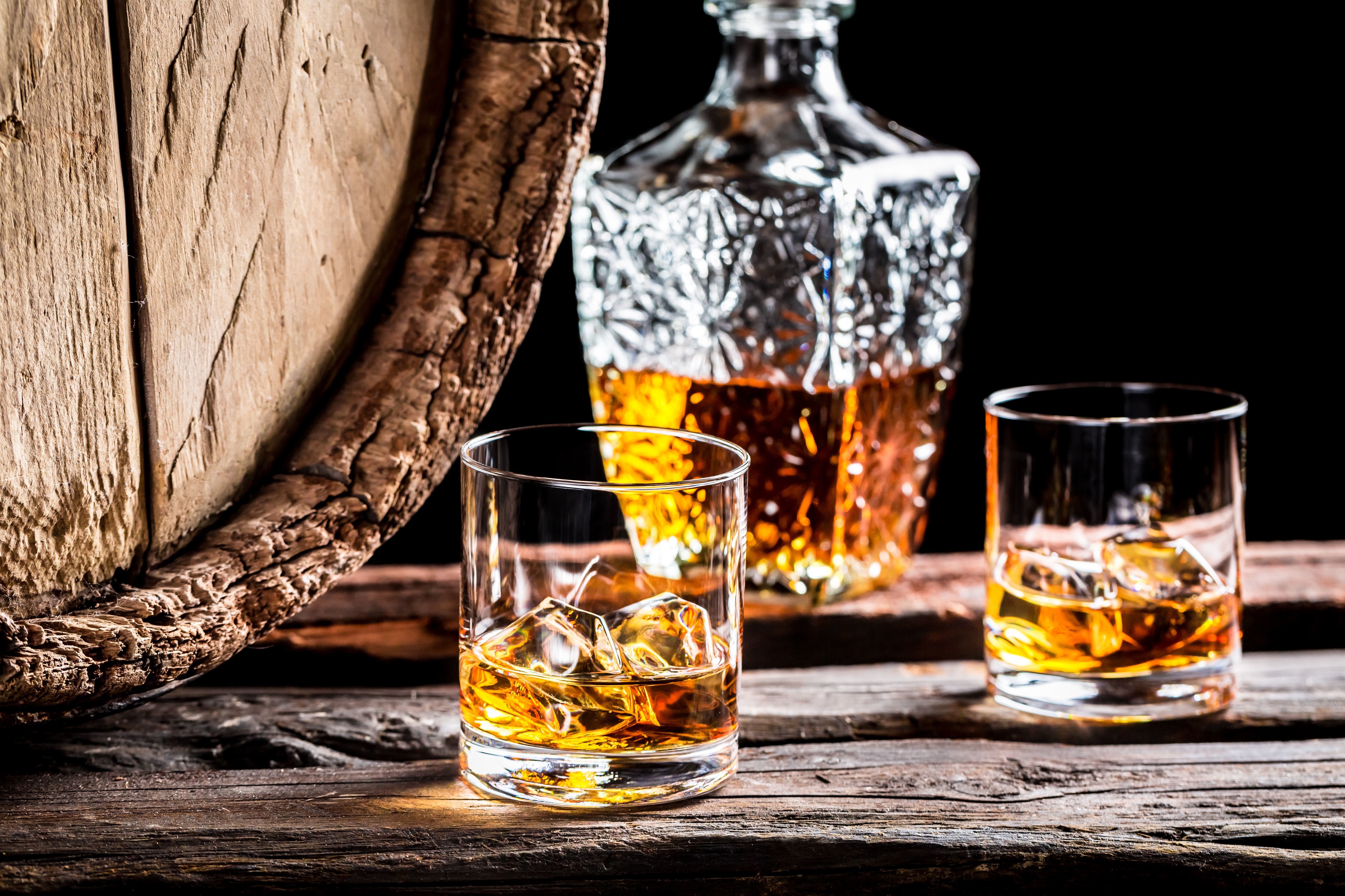 Whisky in glasses next to a barrel and decanter HD Wallpaper