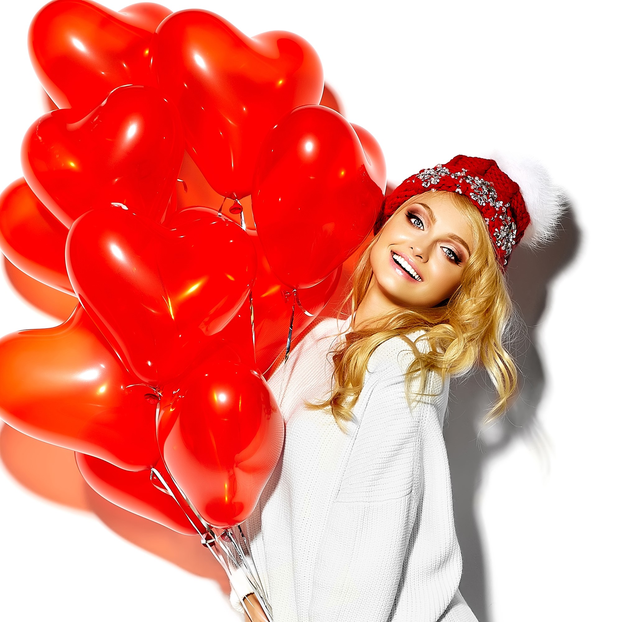 Blonde girl in winter hat holding red heart balloons HD Wallpaper