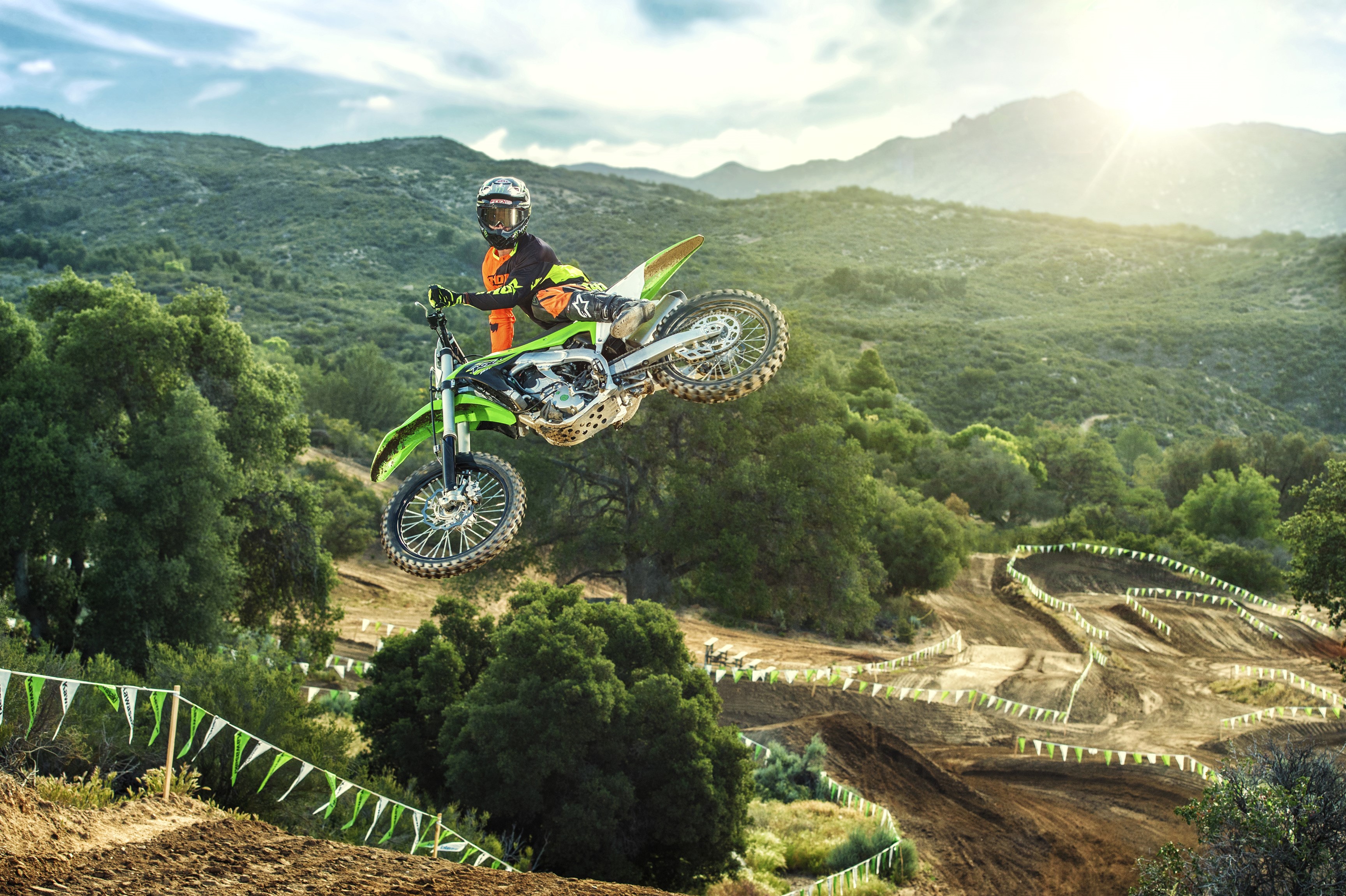 Kawasaki KX250F motocross rider jumping over a track HD Wallpaper