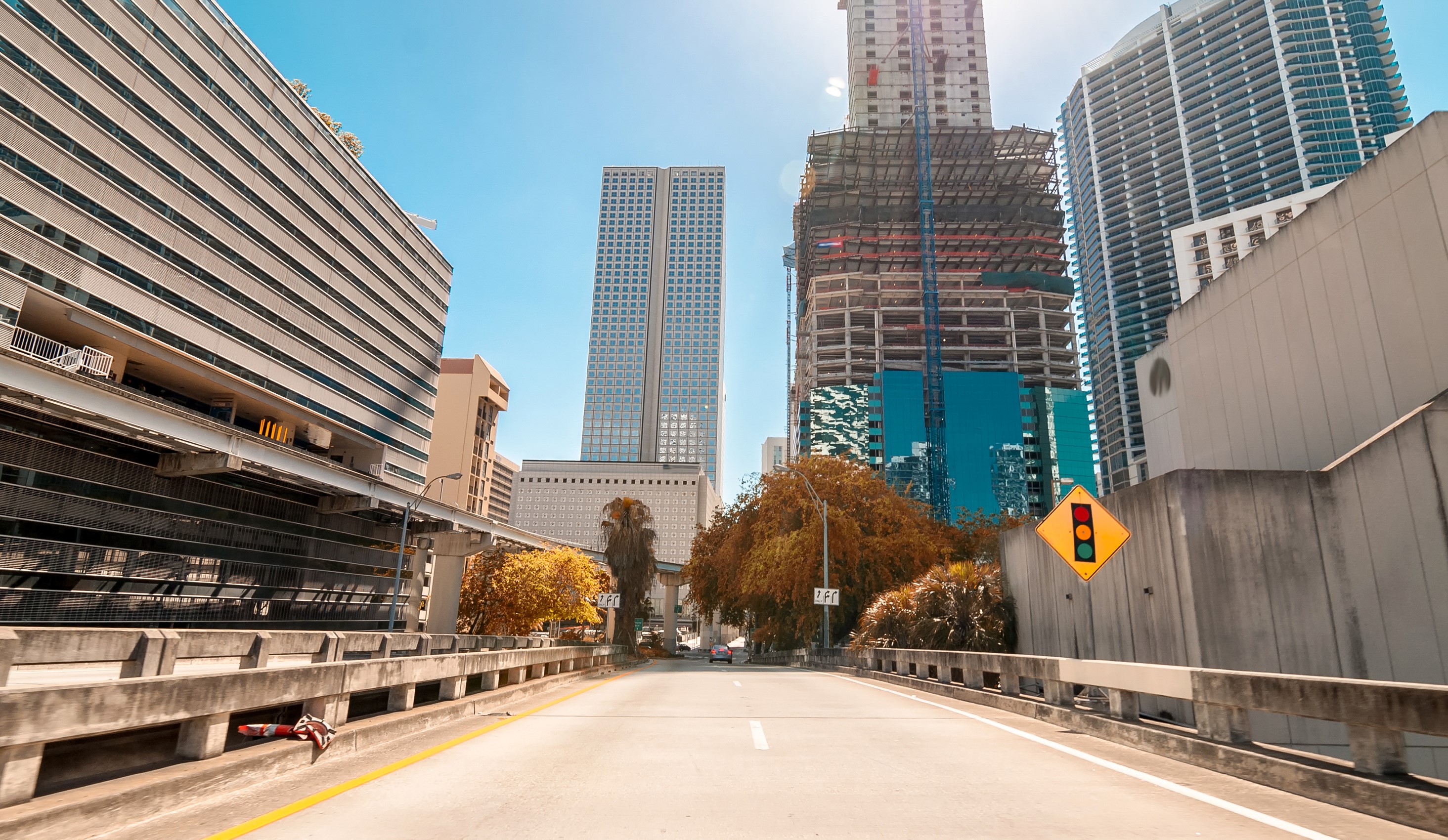 Road leading through Miami skyscrapers and construction sites HD Wallpaper