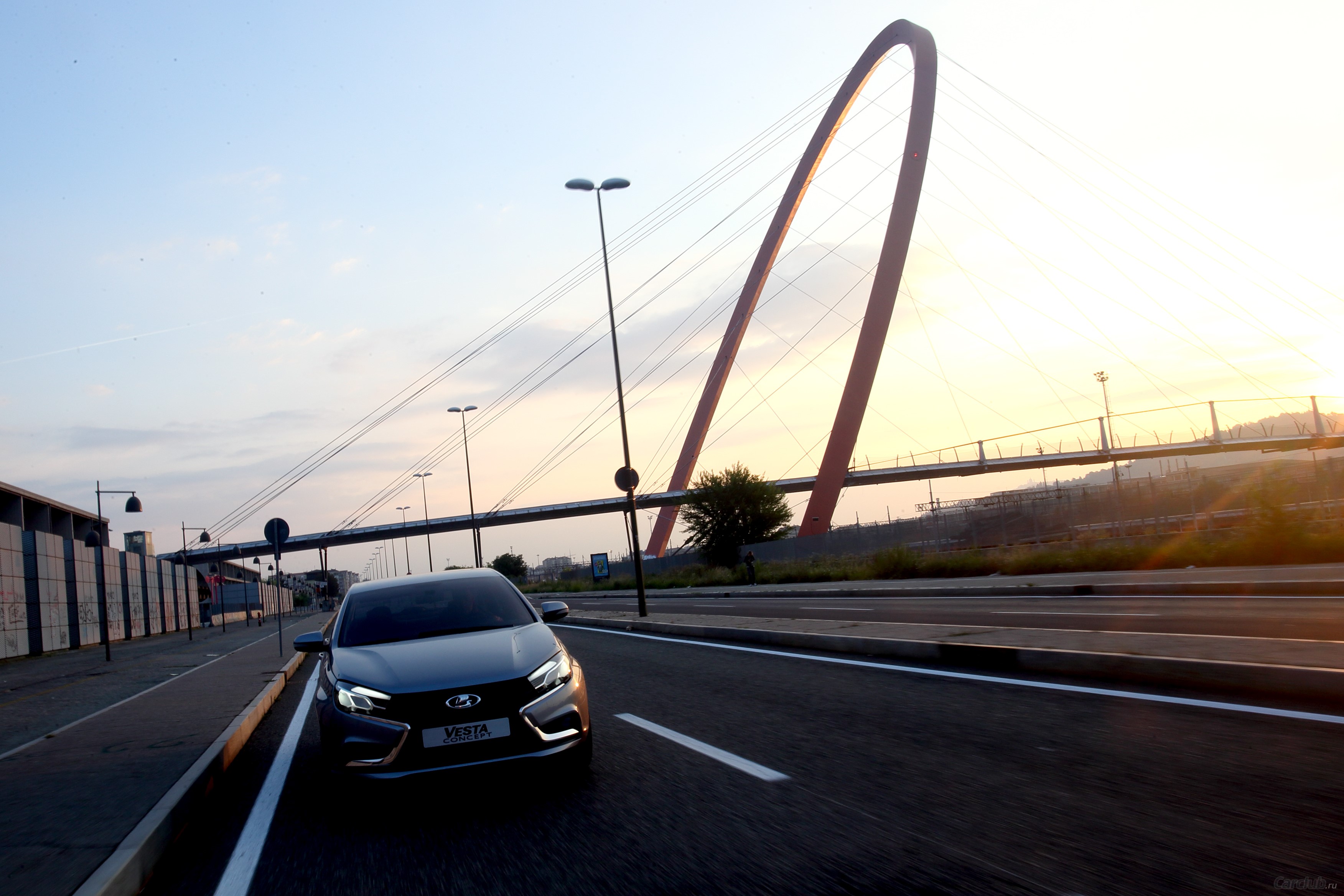Lada Vesta driving on a road near a bridge HD Wallpaper