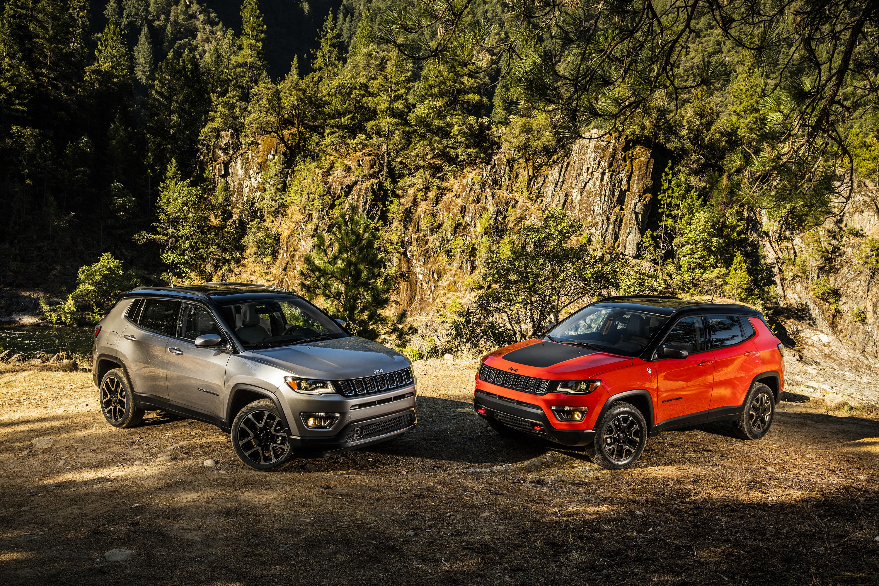 Two Jeep Compass SUVs in a Forest Setting HD Wallpaper
