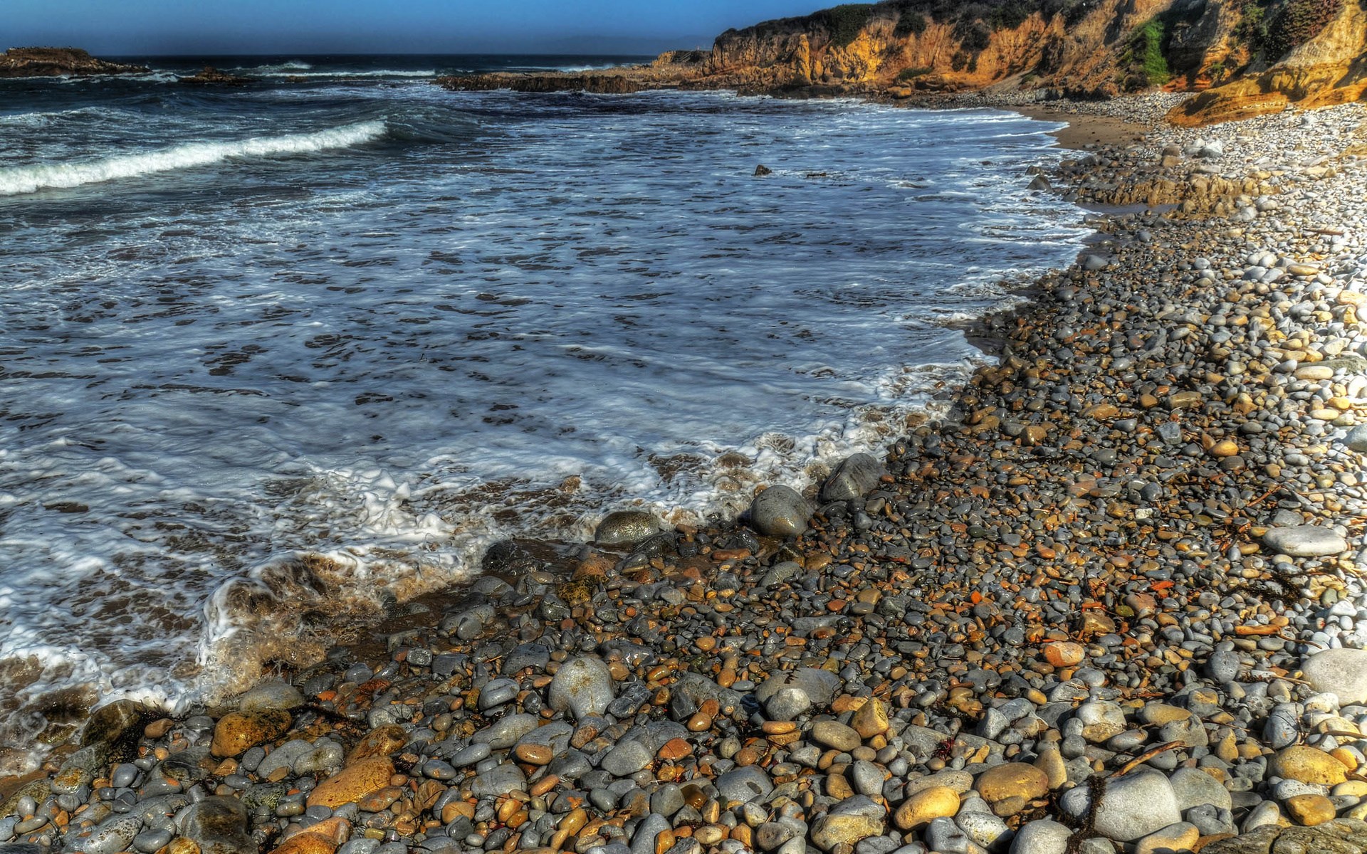 Pebble beach with waves and cliffs HD Wallpaper
