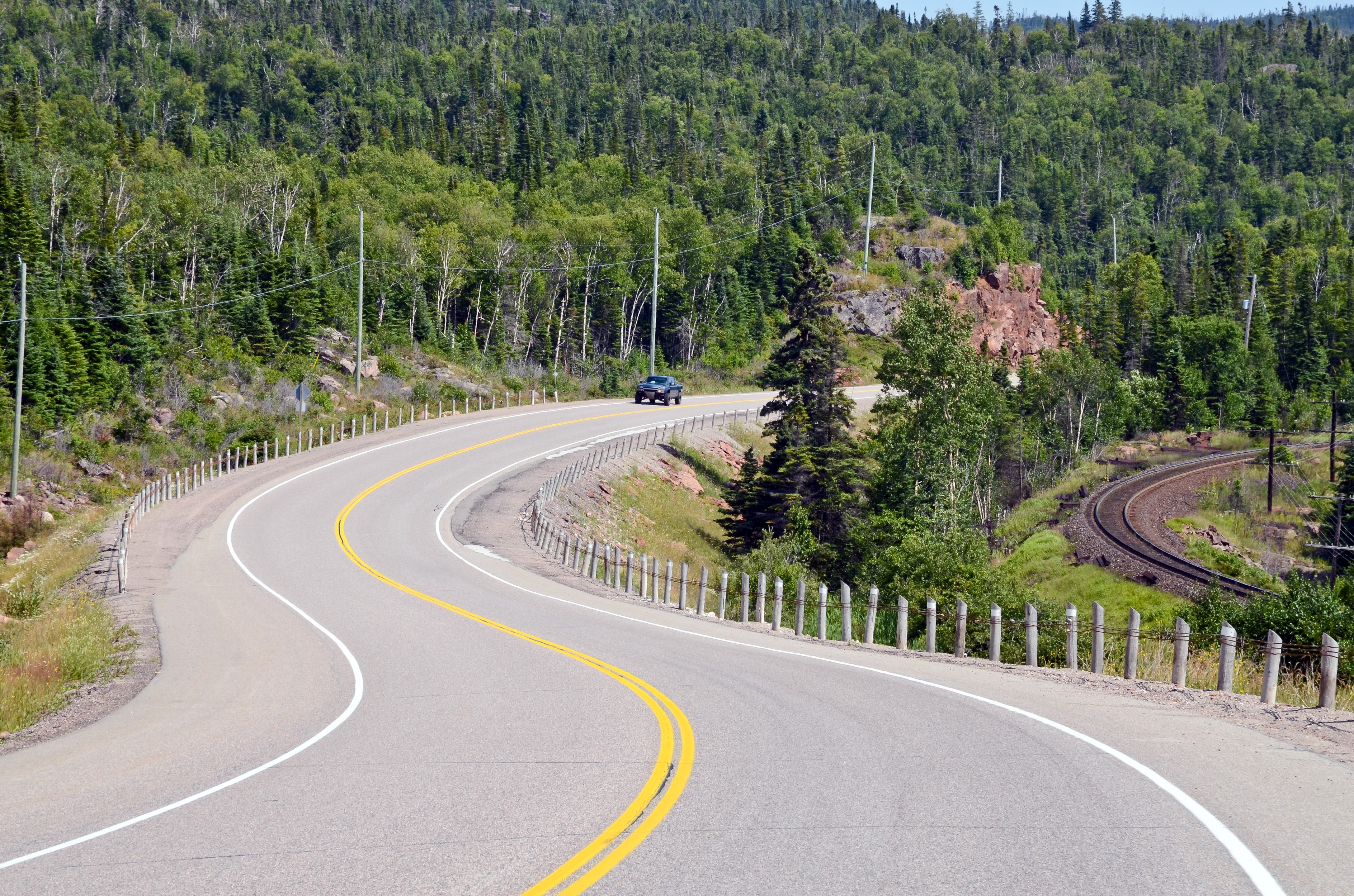 Curving road through a forest in Canada HD Wallpaper