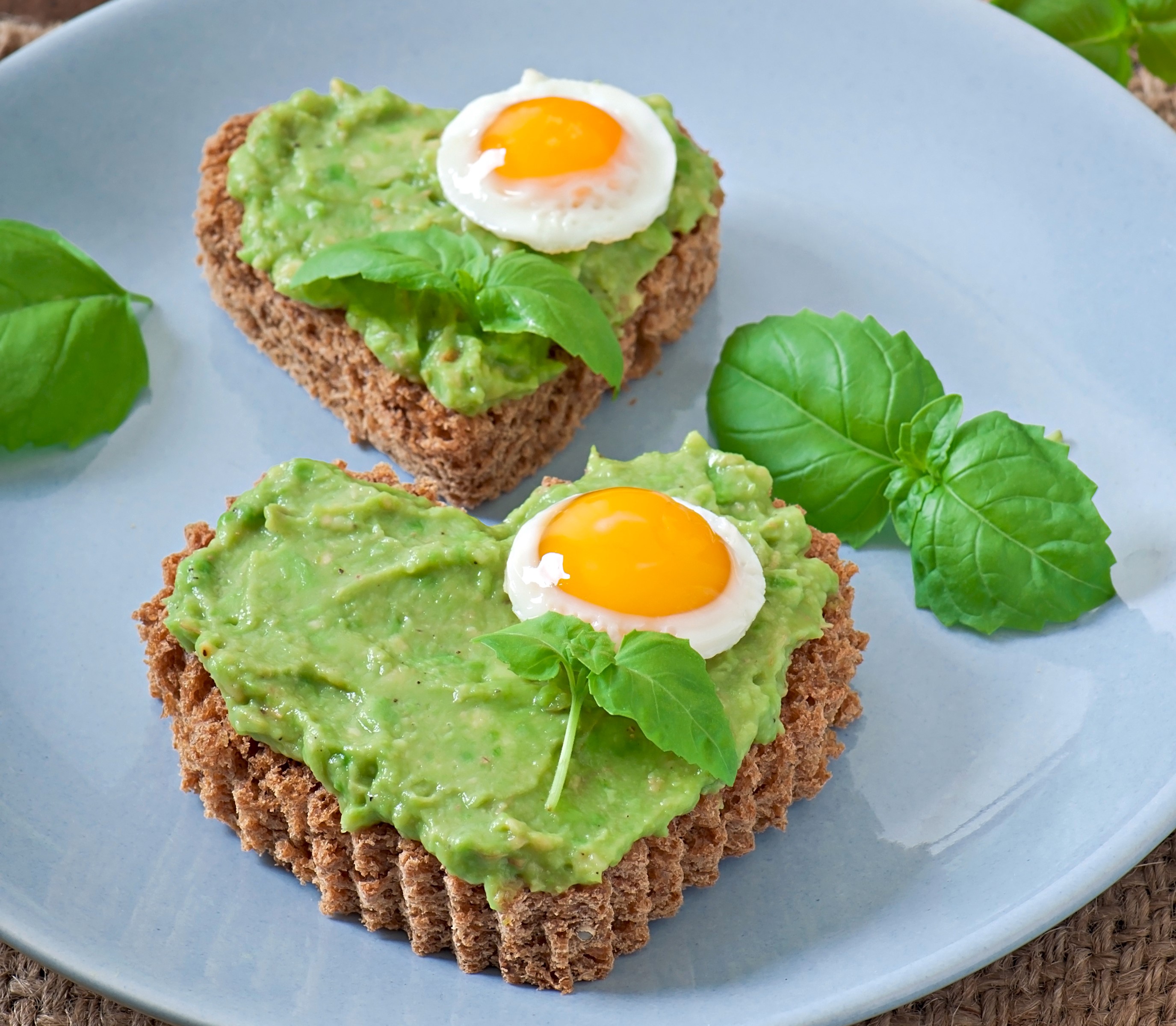 Heart-shaped avocado toast with fried egg and basil HD Wallpaper