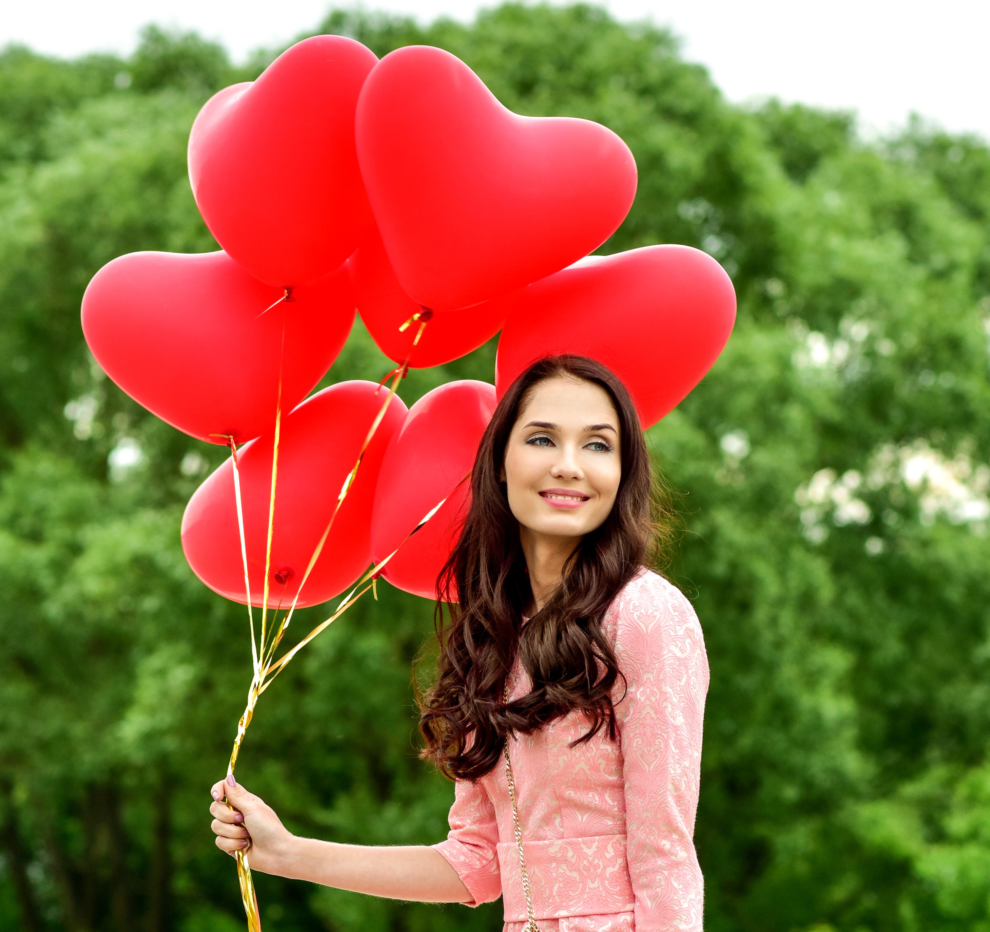 Woman holding red heart balloons outdoors HD Wallpaper