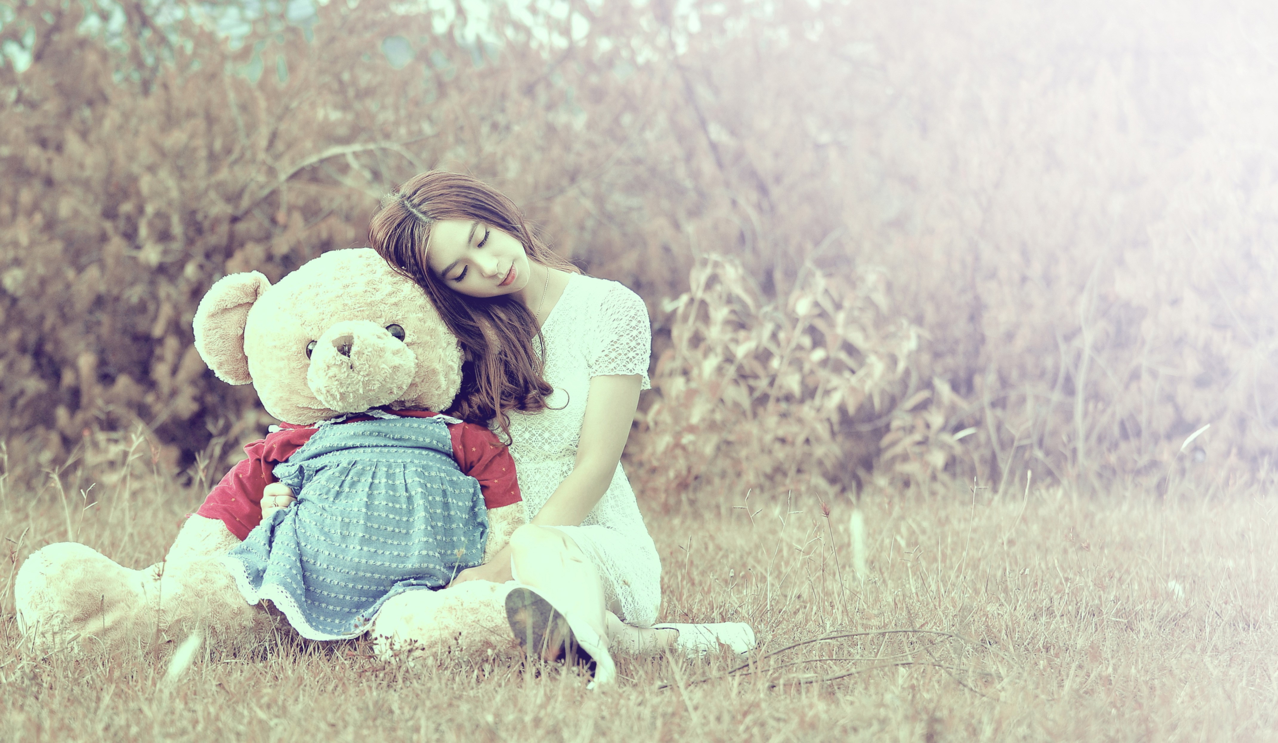 Asian girl with teddy bear in field HD Wallpaper