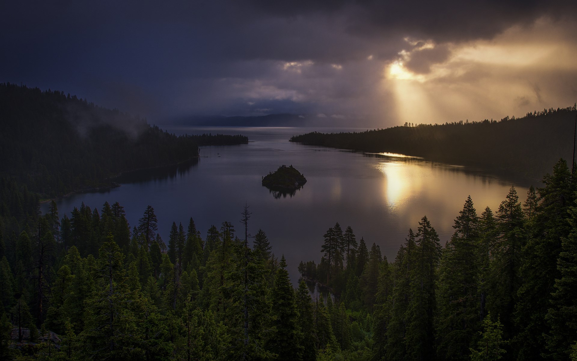 Lake with an island and sunbeams through clouds HD Wallpaper