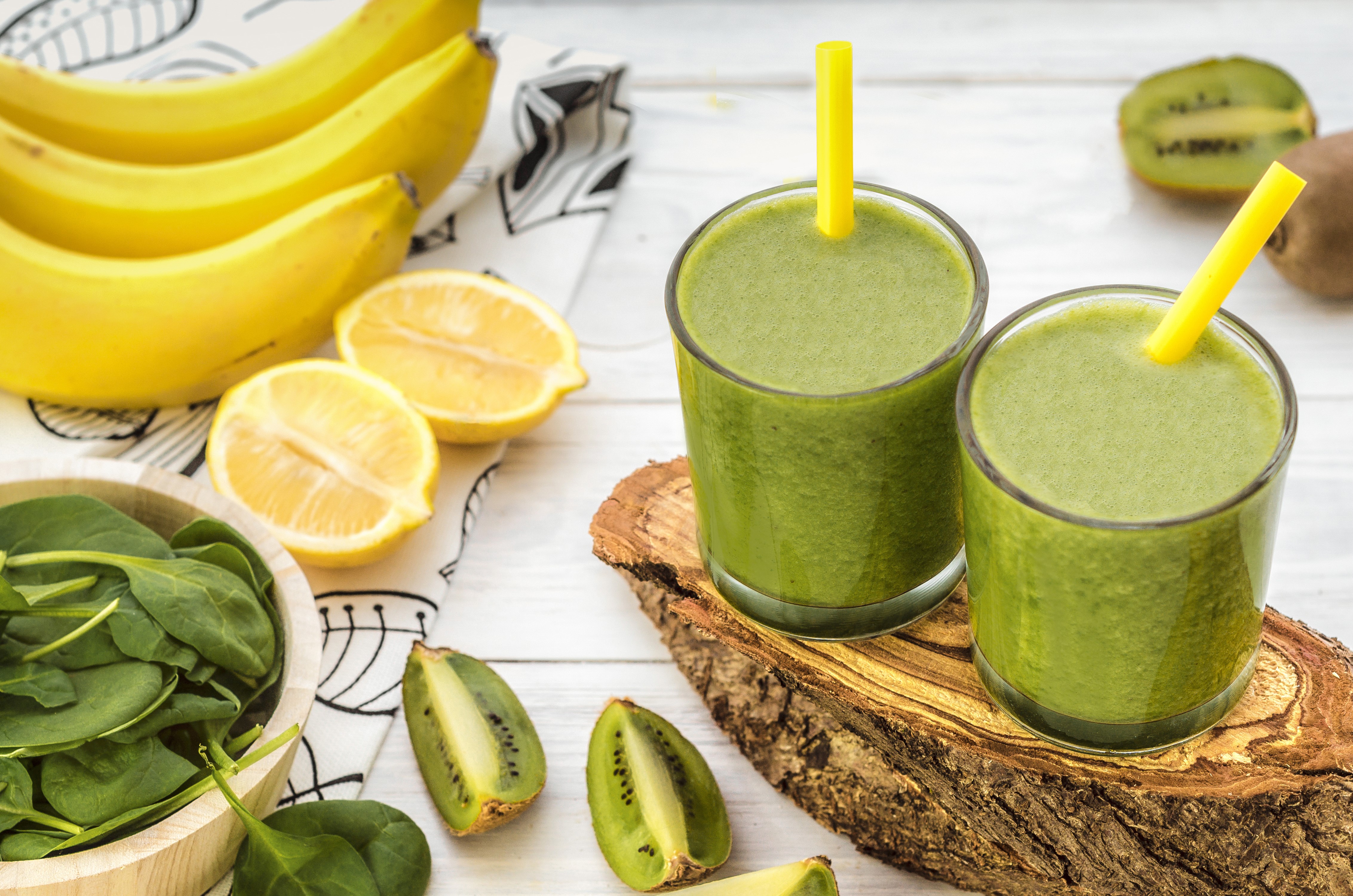 Two glasses of green smoothie with kiwi, bananas, lemons, and spinach HD Wallpaper