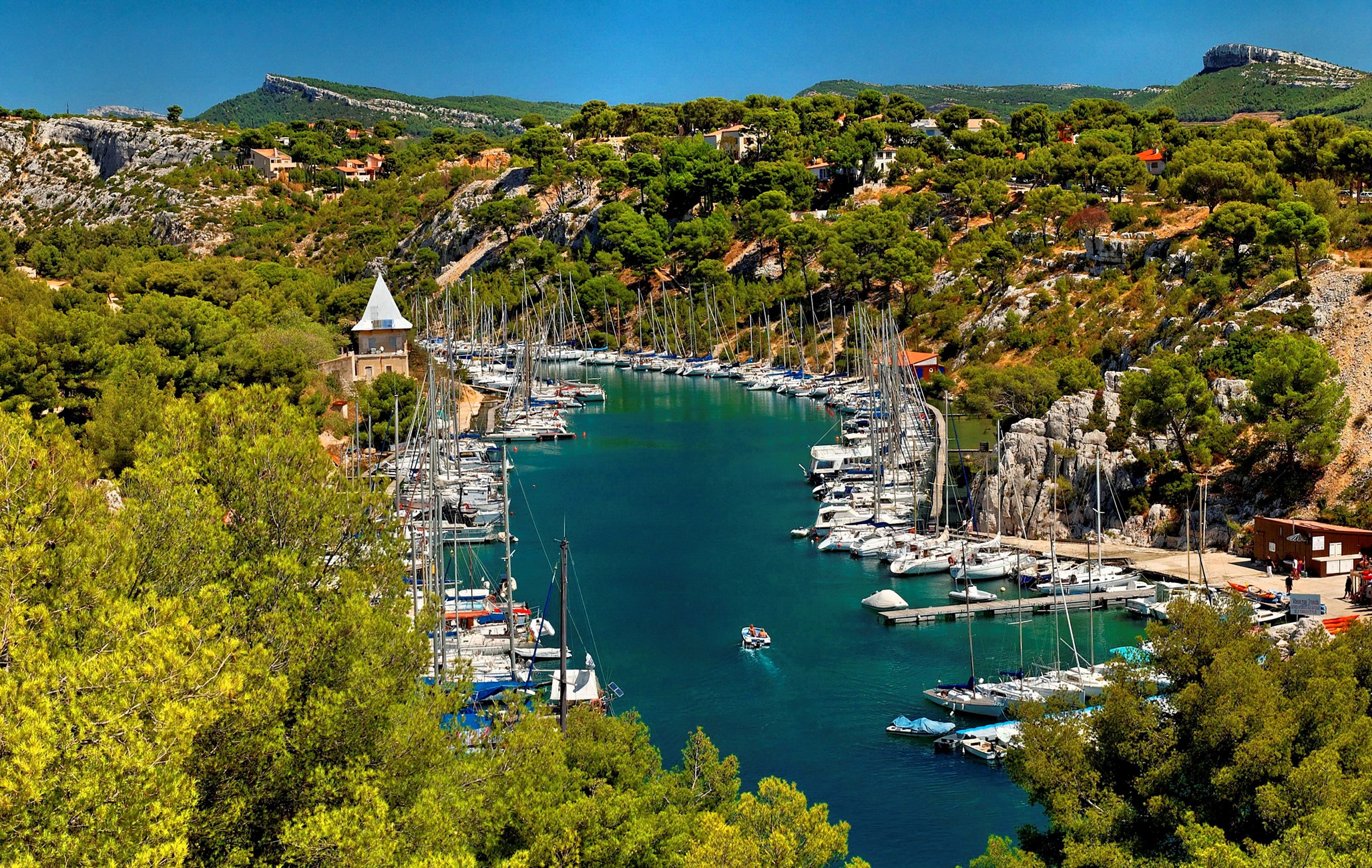 Boats docked in a scenic cove in Cassis, France HD Wallpaper
