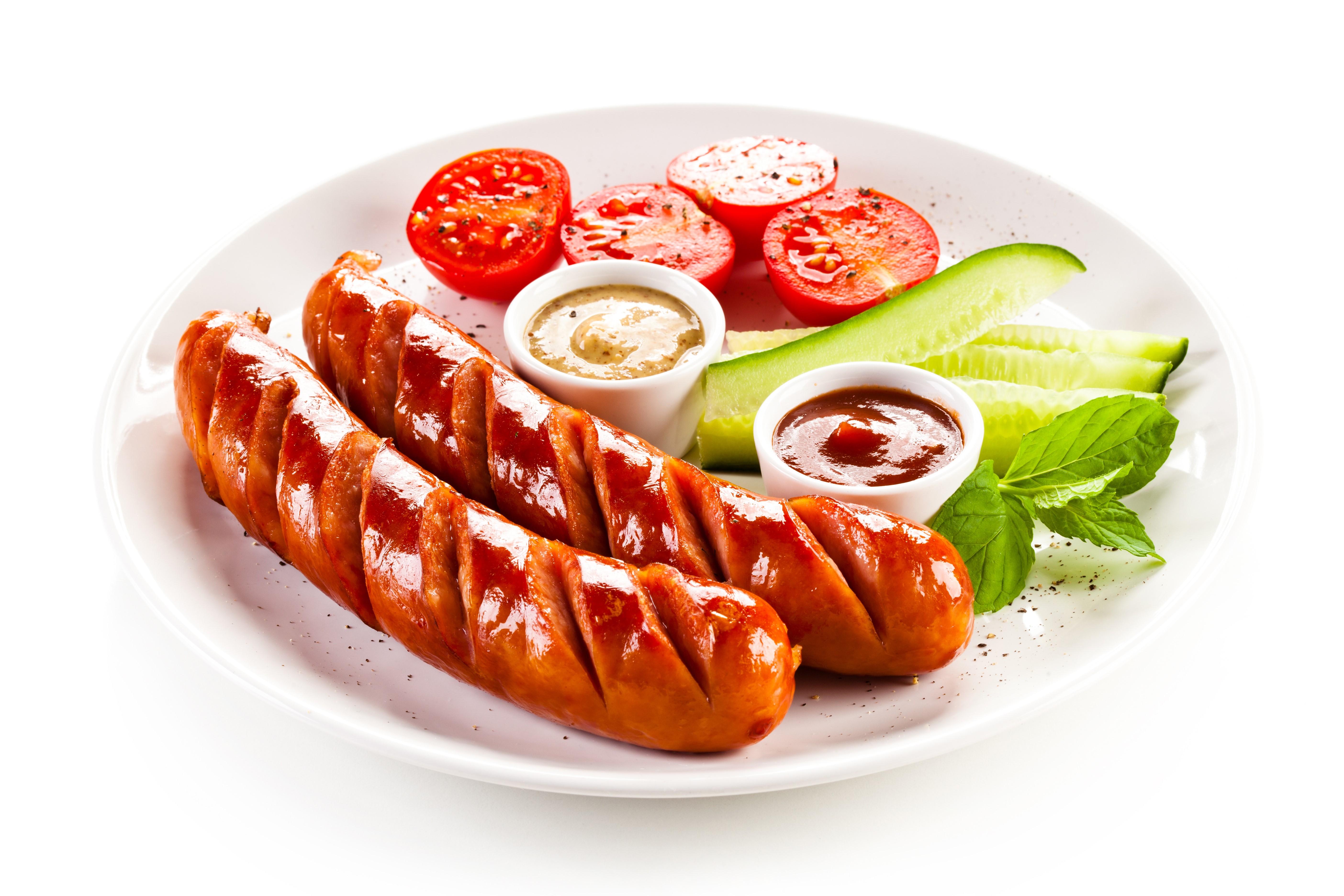 Sausages with tomatoes, cucumber, and sauces on a plate HD Wallpaper