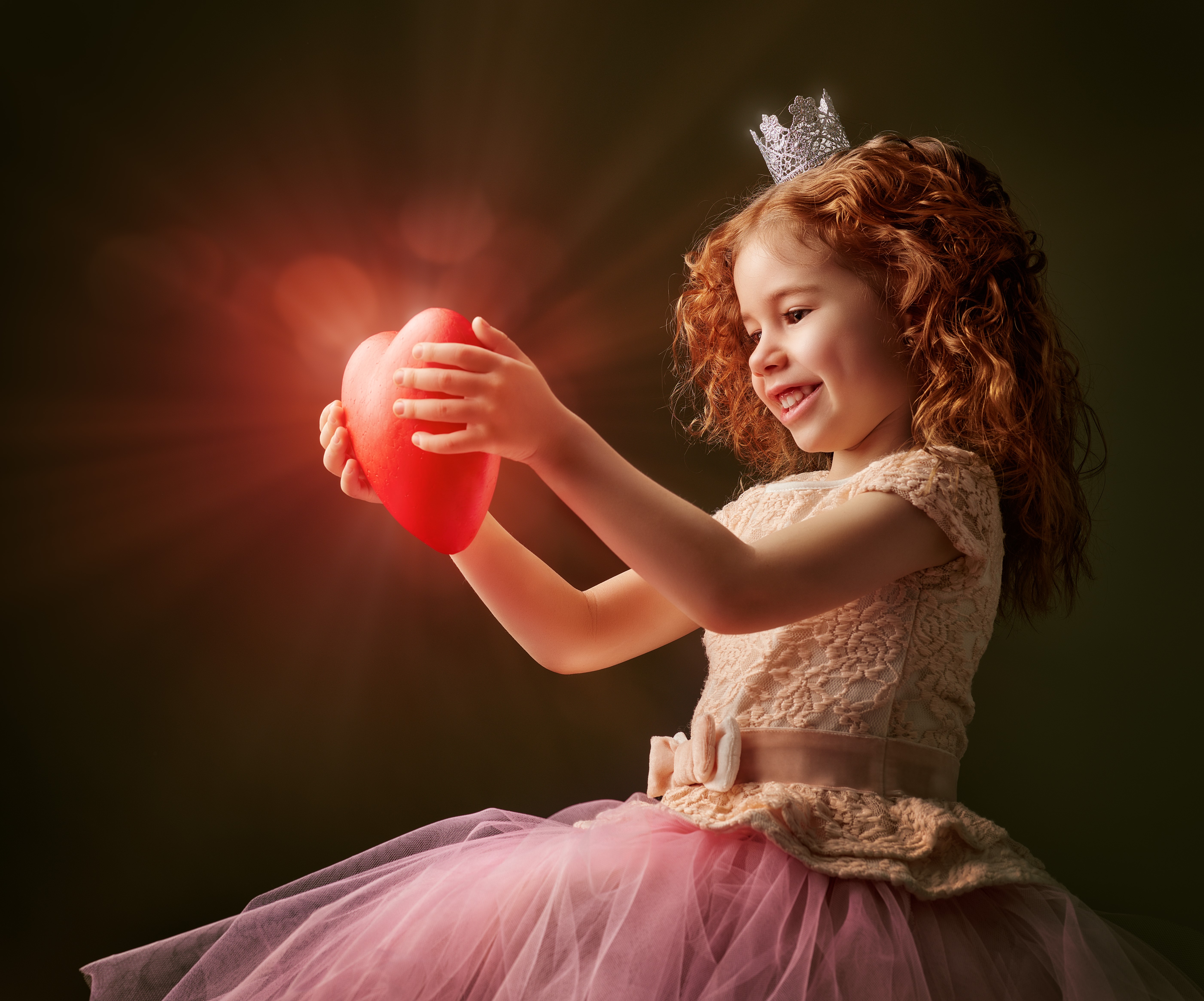 Little girl with crown holding a glowing heart HD Wallpaper