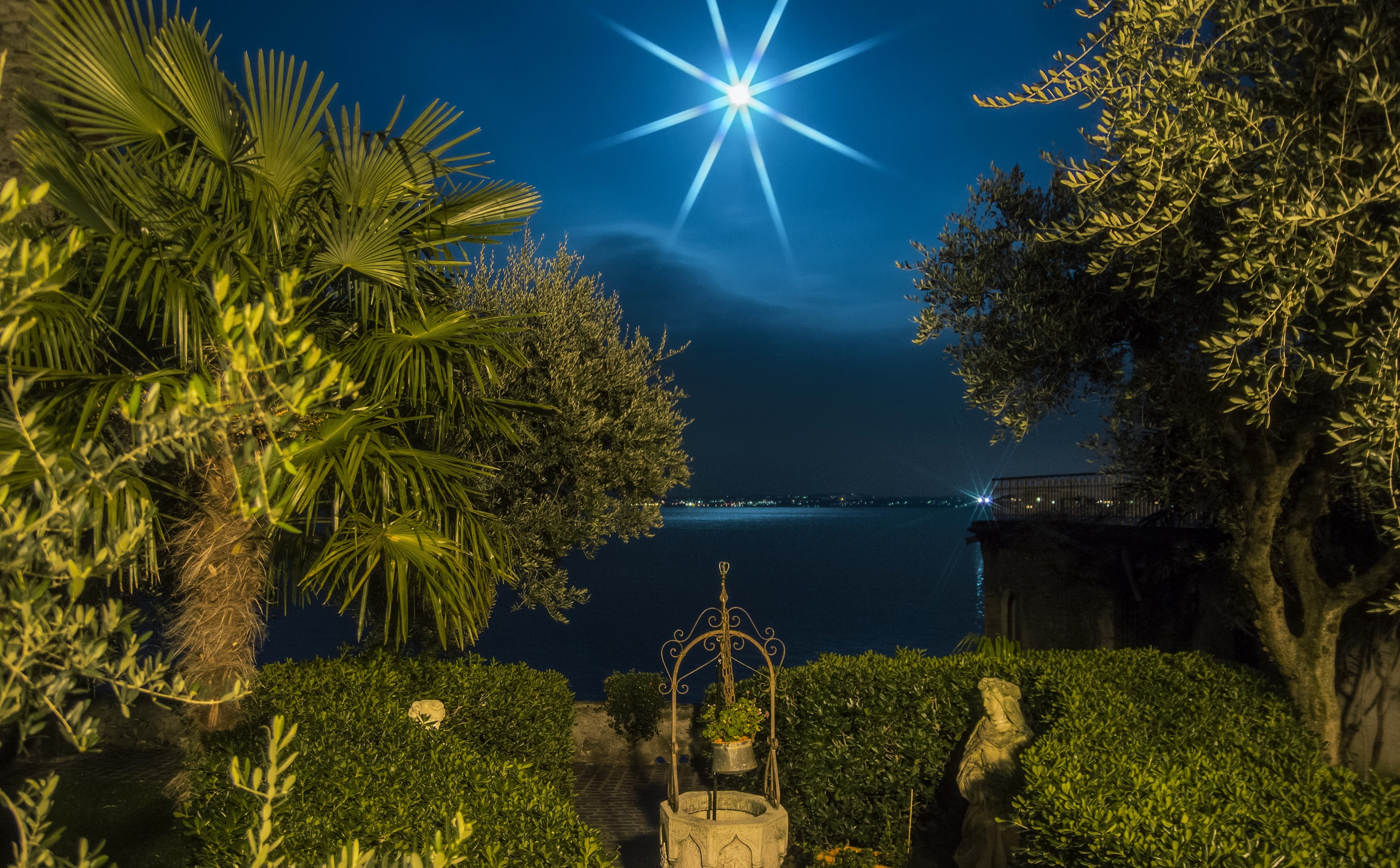 Night view of Sirmione, Lombardy, Italy with moon and palm trees HD Wallpaper