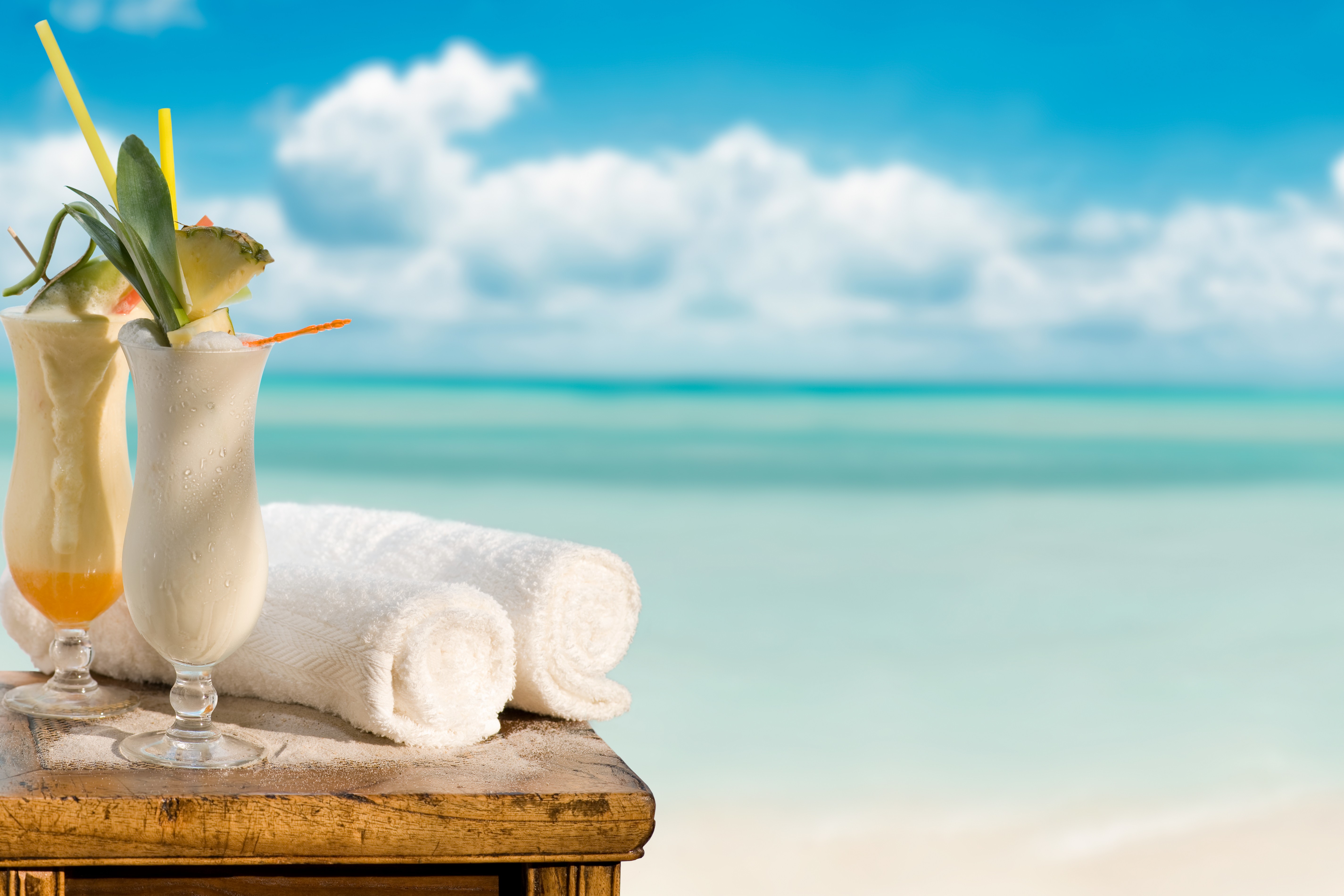 Cocktails and towels on a table by the sea HD Wallpaper