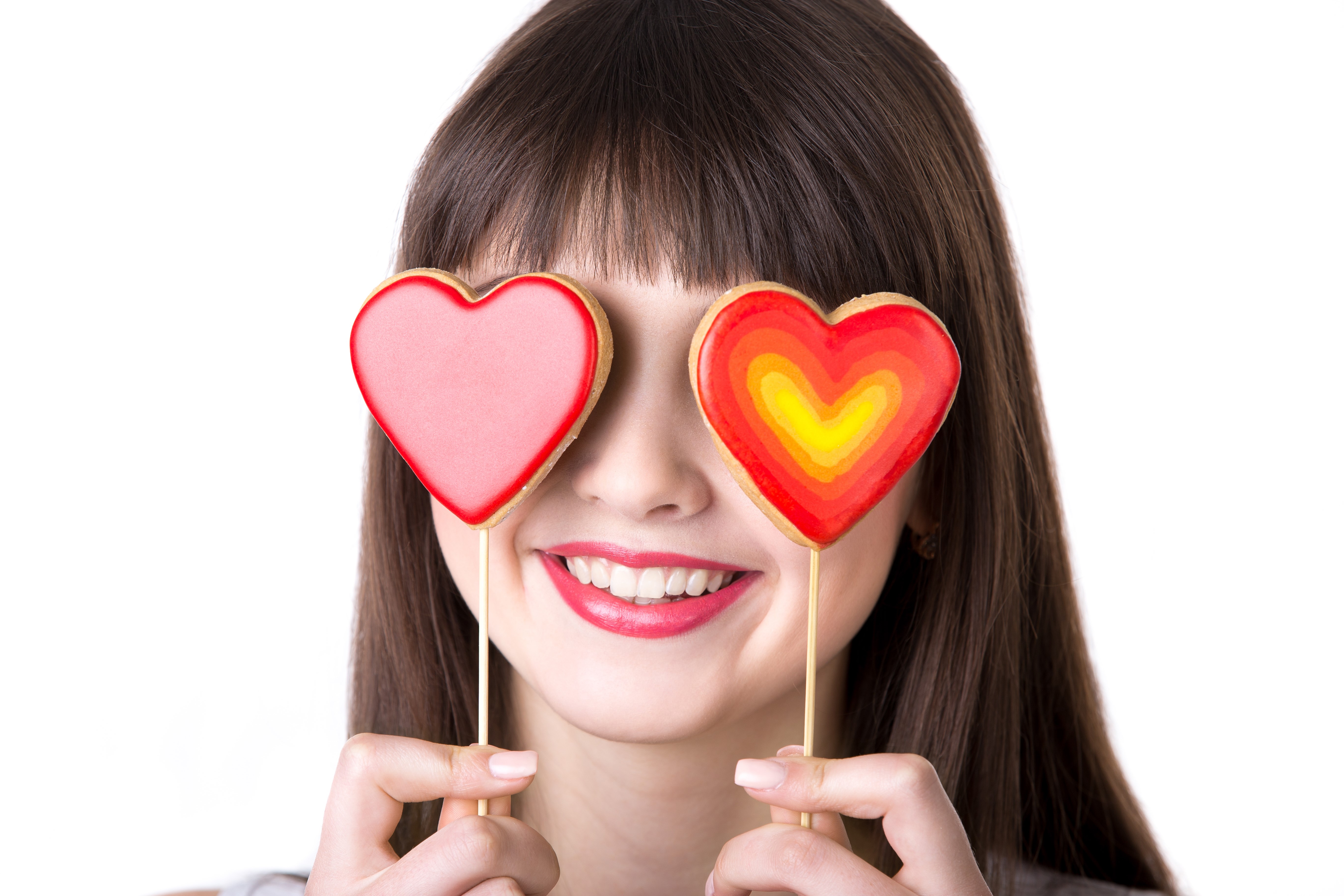 Woman holding heart cookies over eyes HD Wallpaper