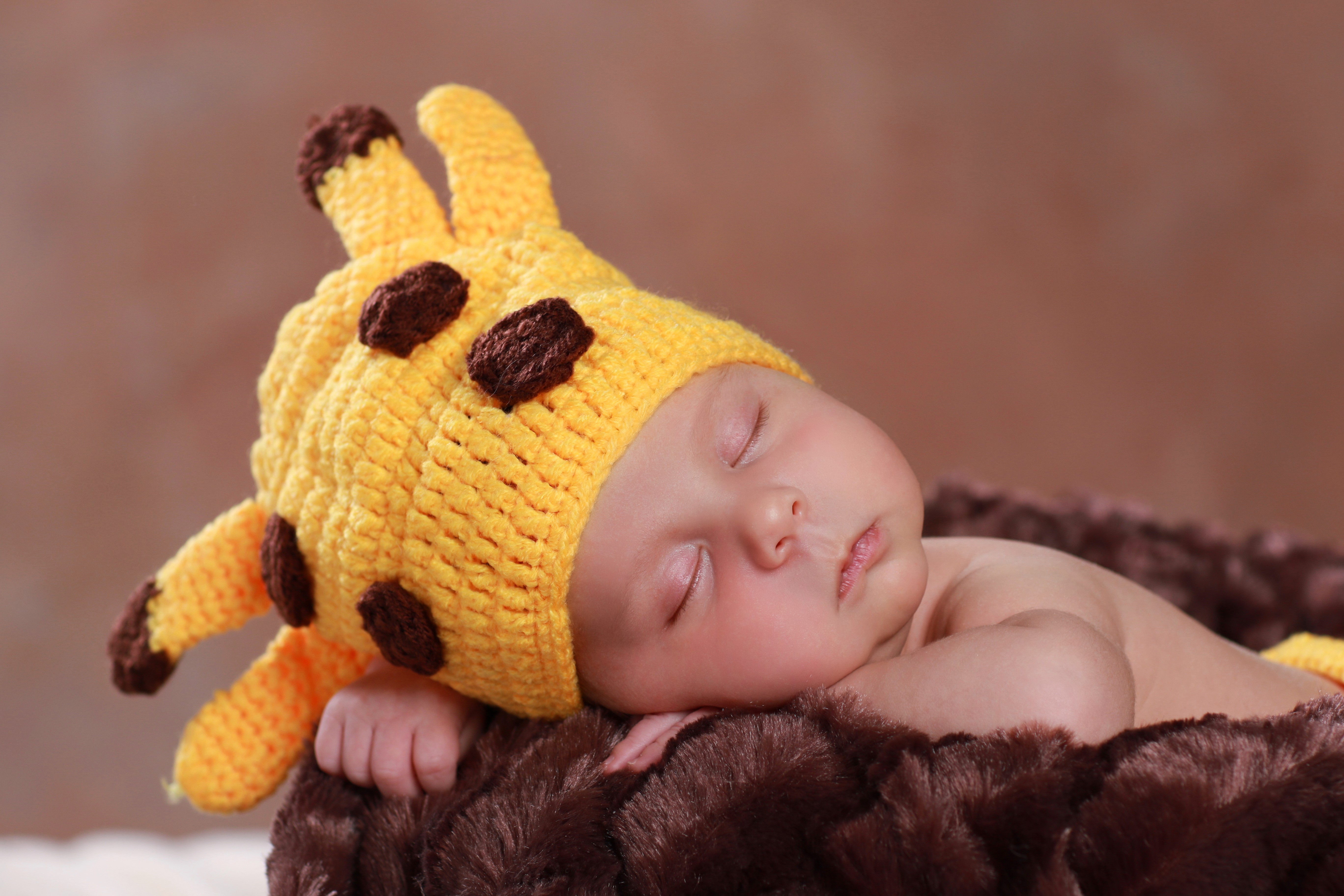 Baby sleeping in giraffe hat HD Wallpaper