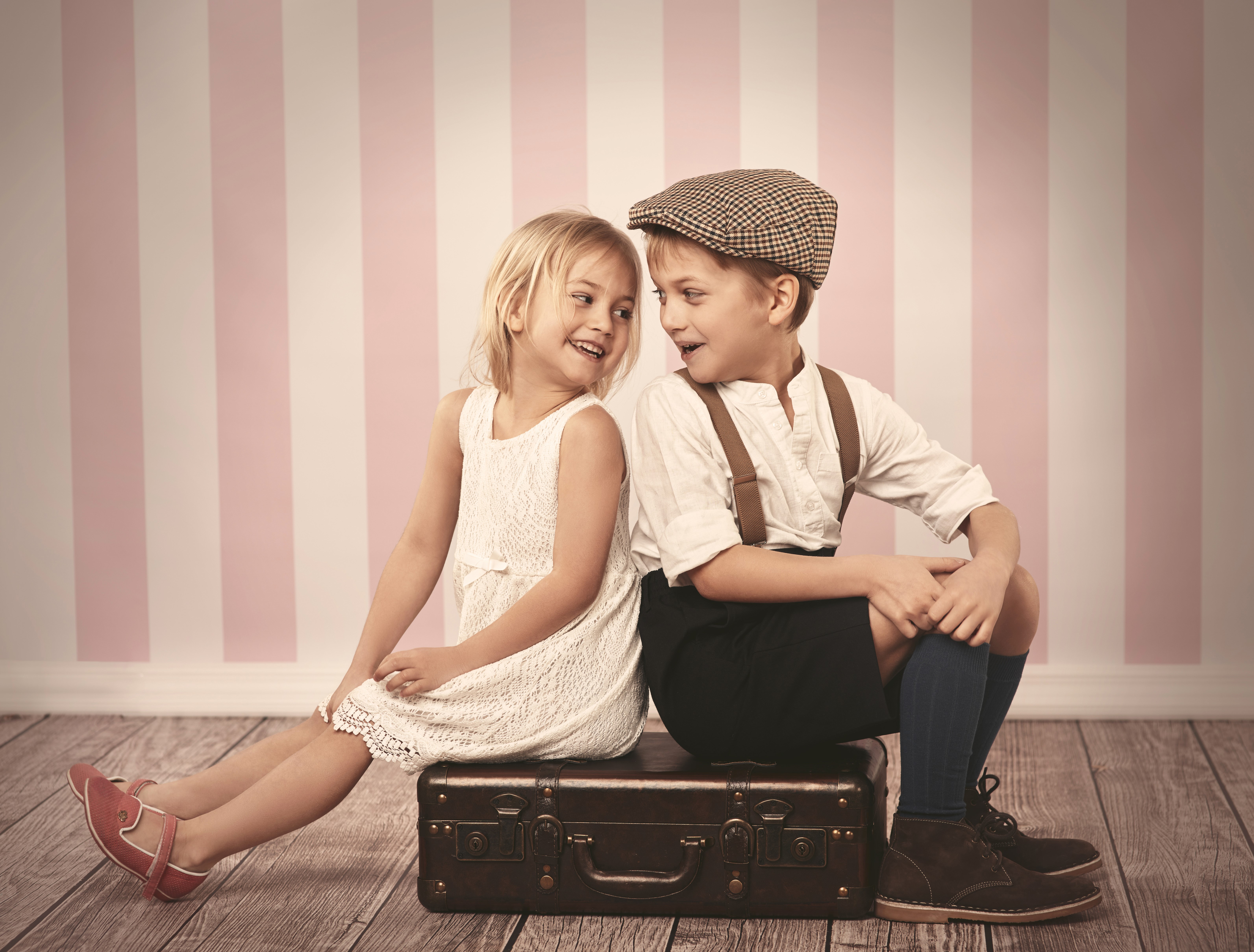 Boy and girl sitting on a suitcase HD Wallpaper