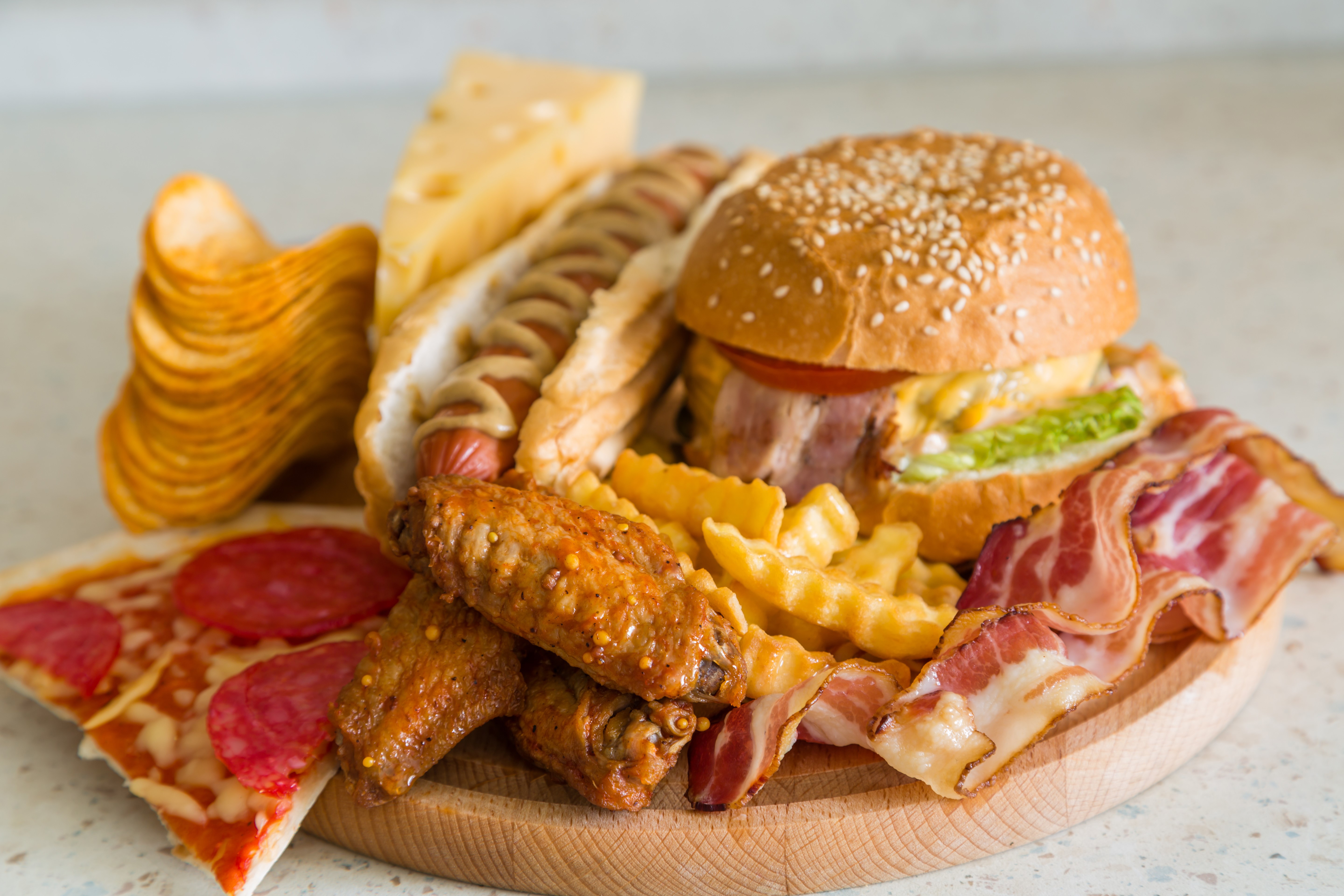 Fast food assortment: hamburger, pizza, hot dog, wings, fries, bacon, chips, cheese HD Wallpaper