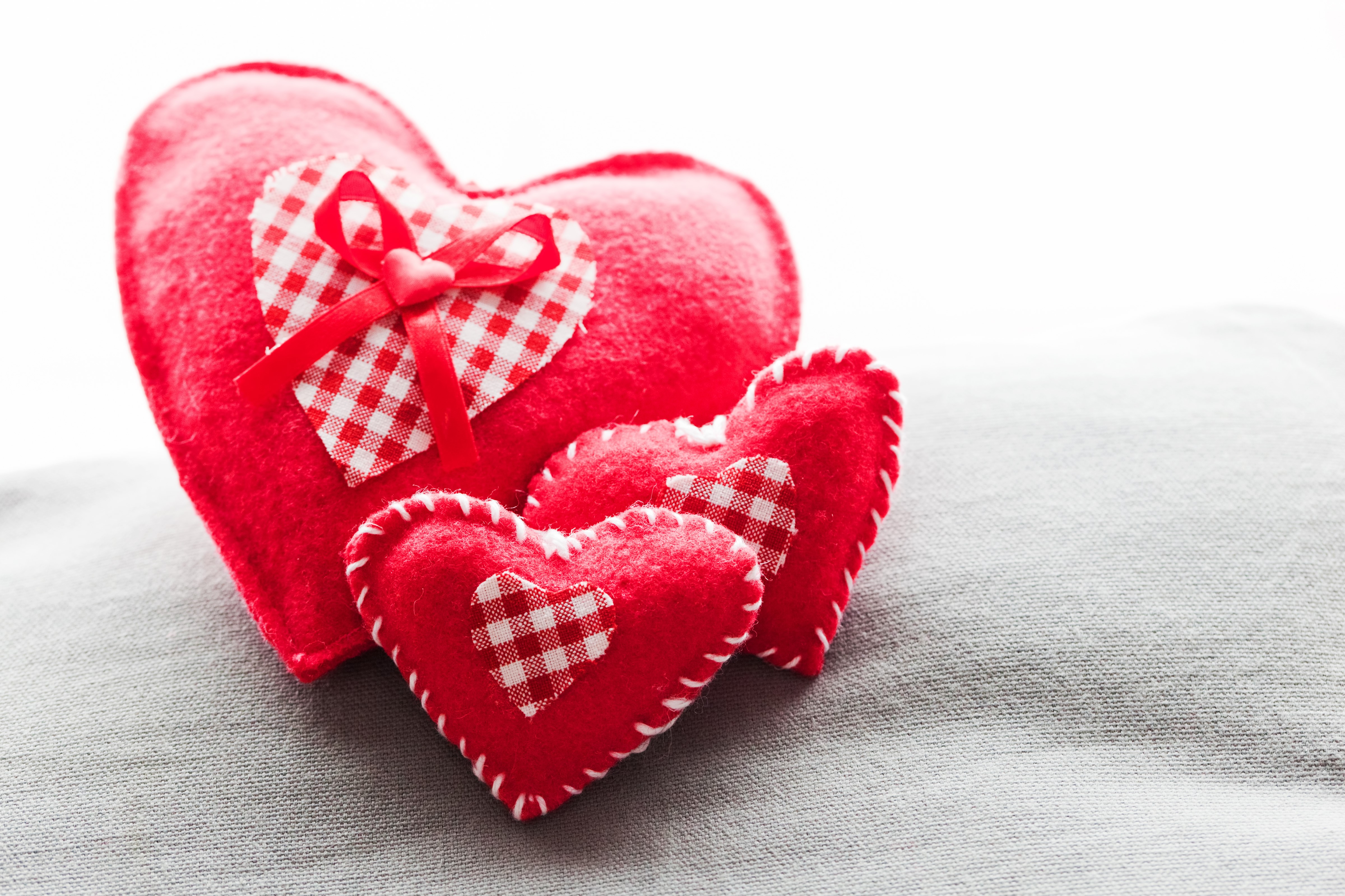 Three red hearts with checkered bows HD Wallpaper