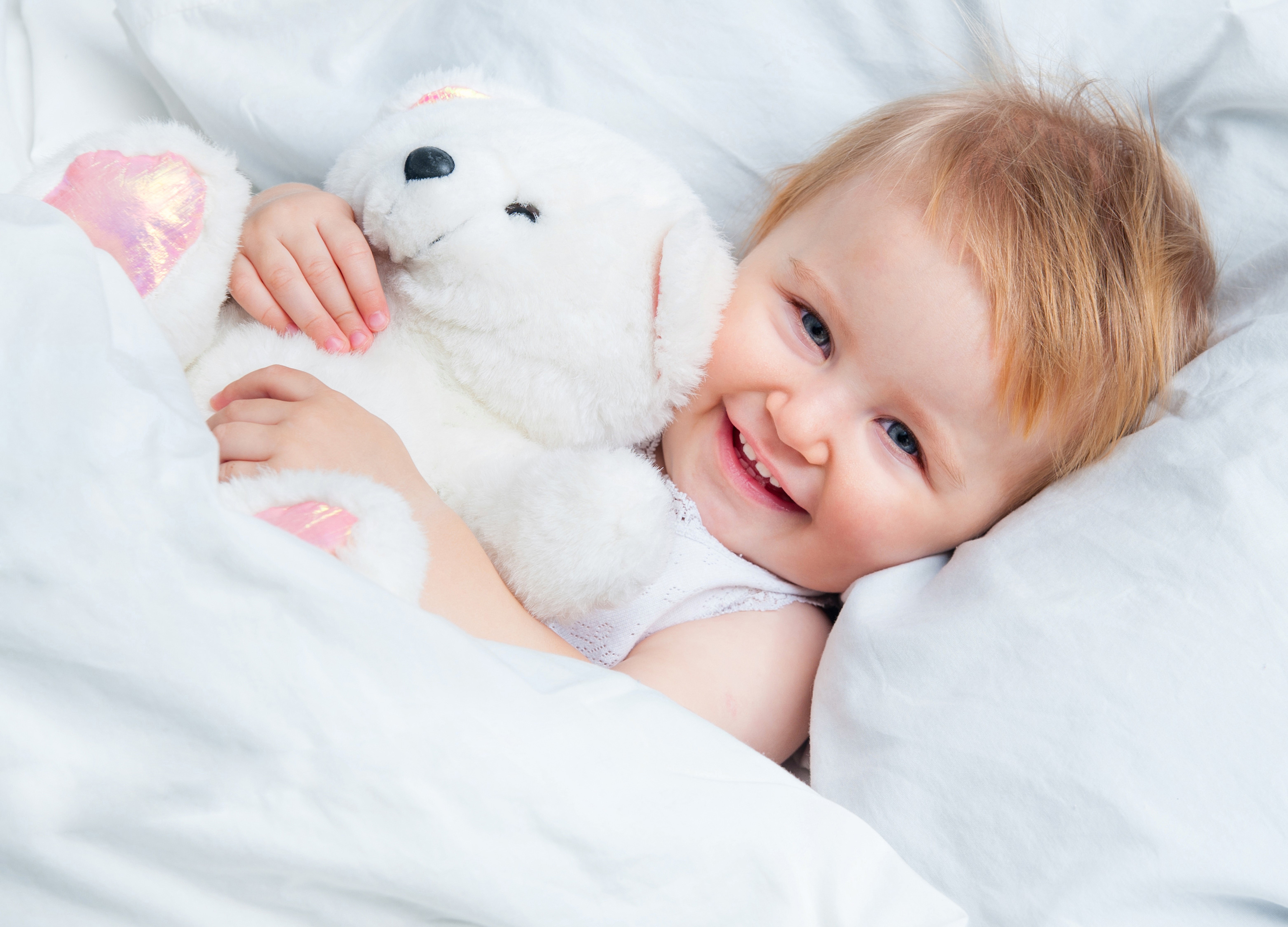 Infant smiling with a teddy bear HD Wallpaper