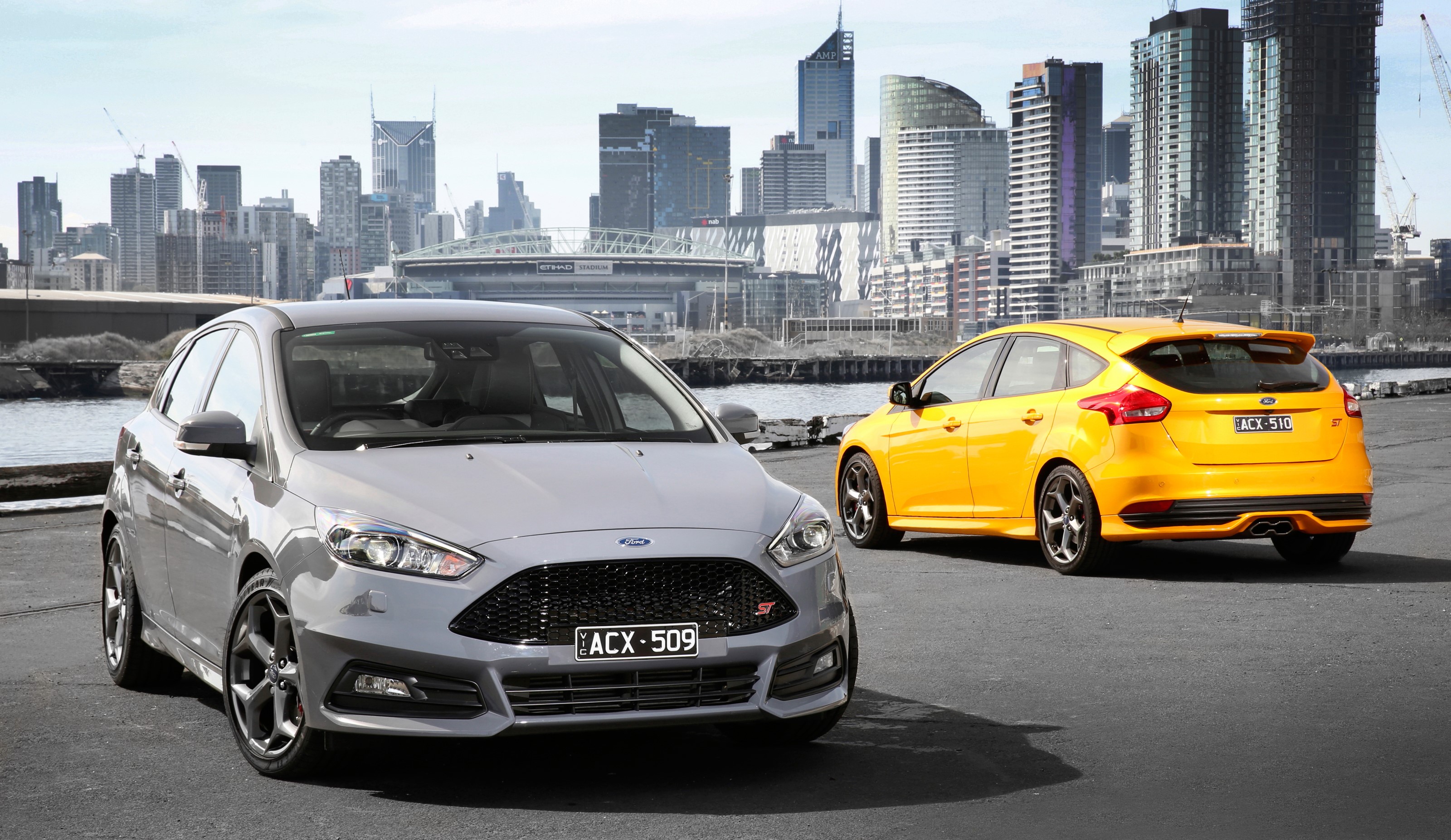 Two Ford Focus ST cars in front of a city skyline HD Wallpaper