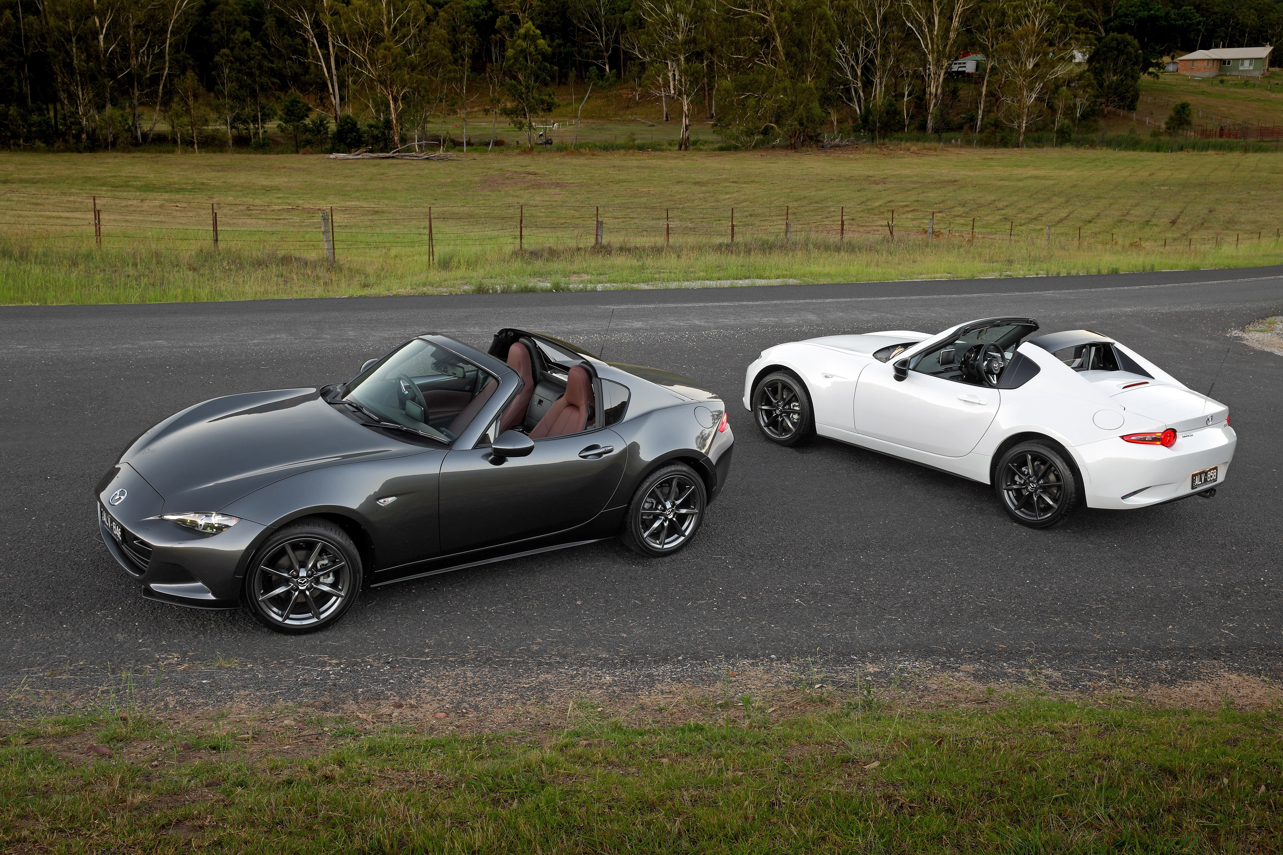 Two Mazda MX-5 RF convertibles on a road HD Wallpaper
