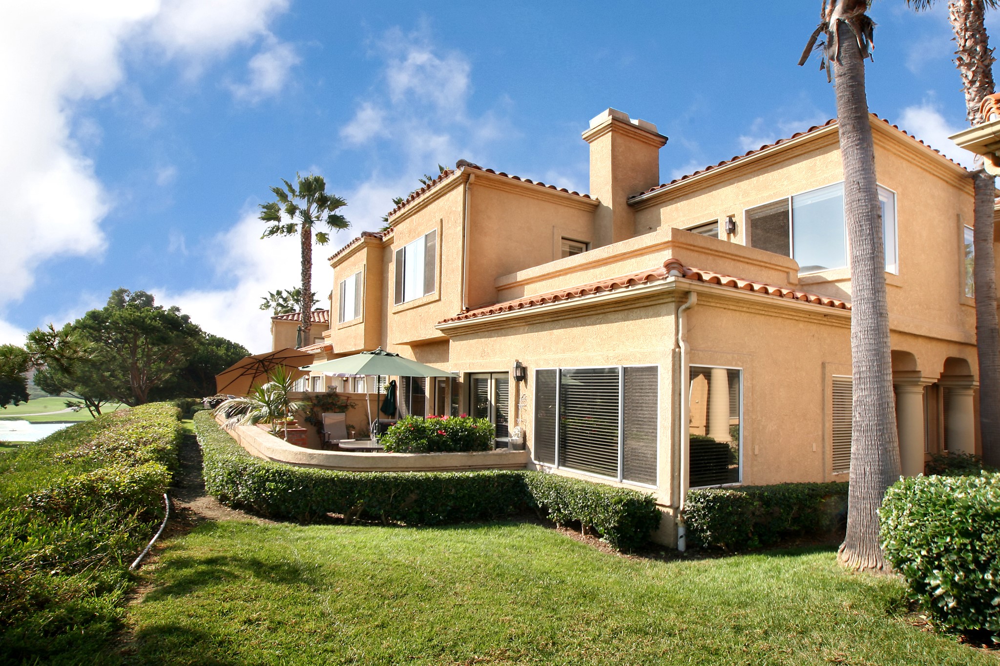 Two-story house with palm trees and manicured lawn HD Wallpaper