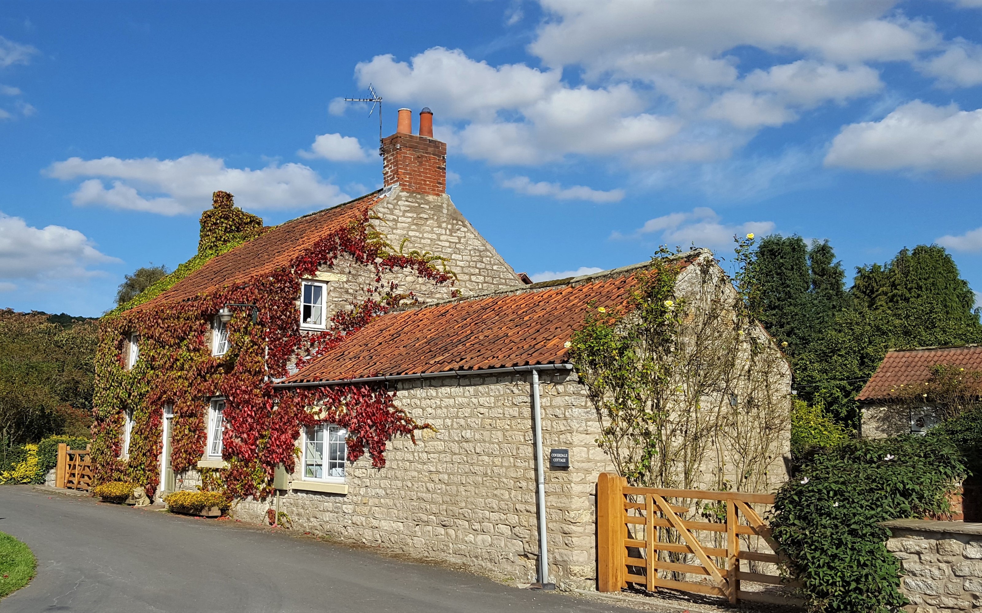 Stone cottage covered in red ivy in Sinnington, North Yorkshire HD Wallpaper