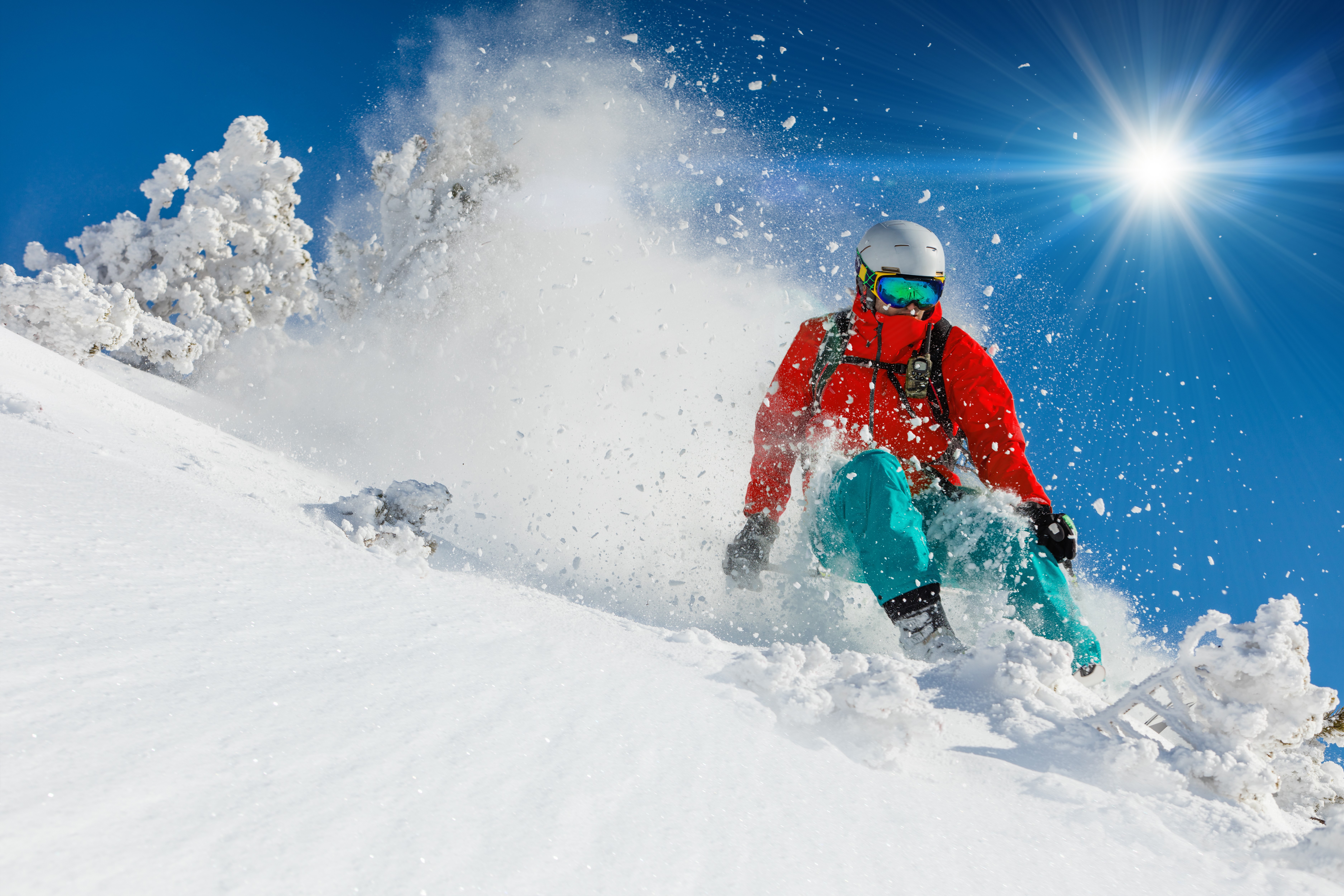 Man skiing down a snowy slope under the sun HD Wallpaper